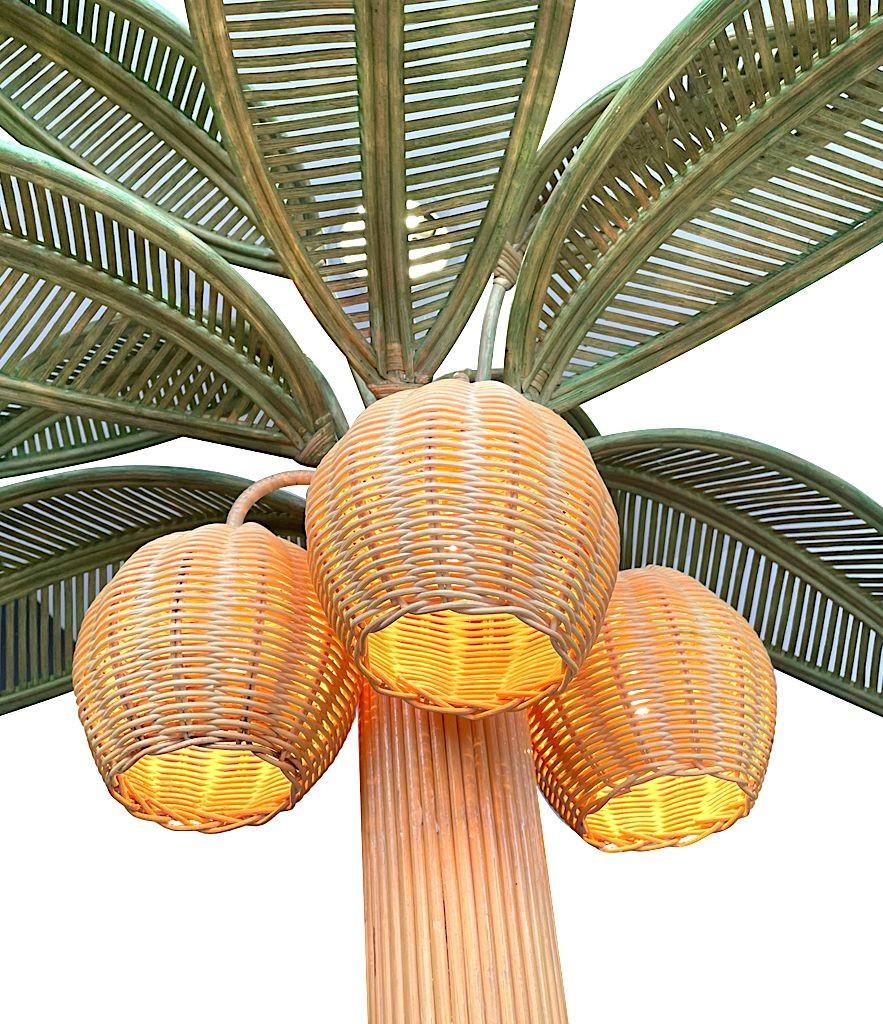 A large bamboo palm tree floor lamp with bulbs in the three coconuts, with green rattan leaves in the style of Mario Lopez Torres.