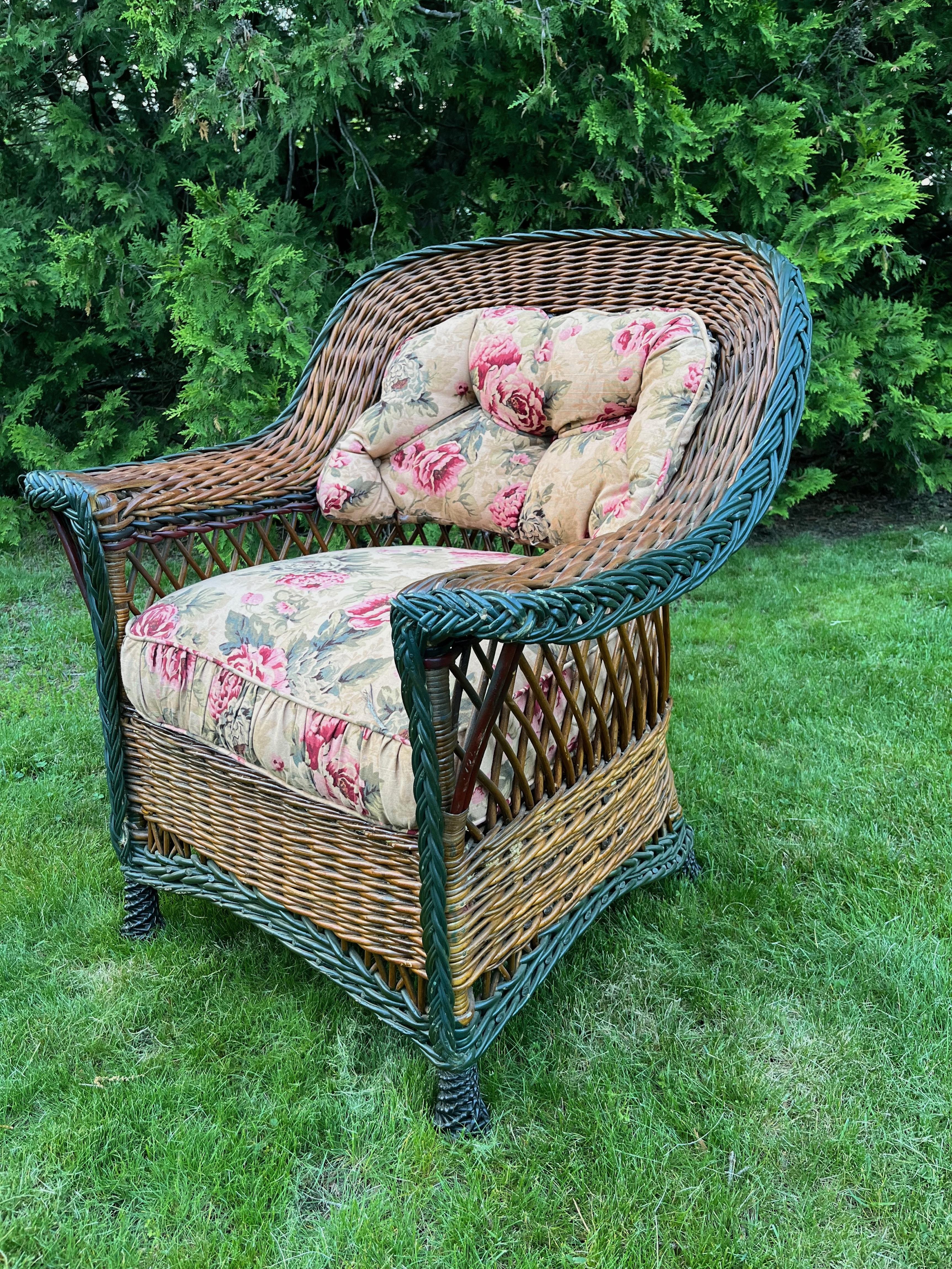 A large and beautiful antique Heywood Wakefield Bar Harbor style wicker arm chair recently acquired from a private estate. It is done in a natural finish with green, maroon and black accent trim, American, circa 1900-1910. 
Large and incredibly