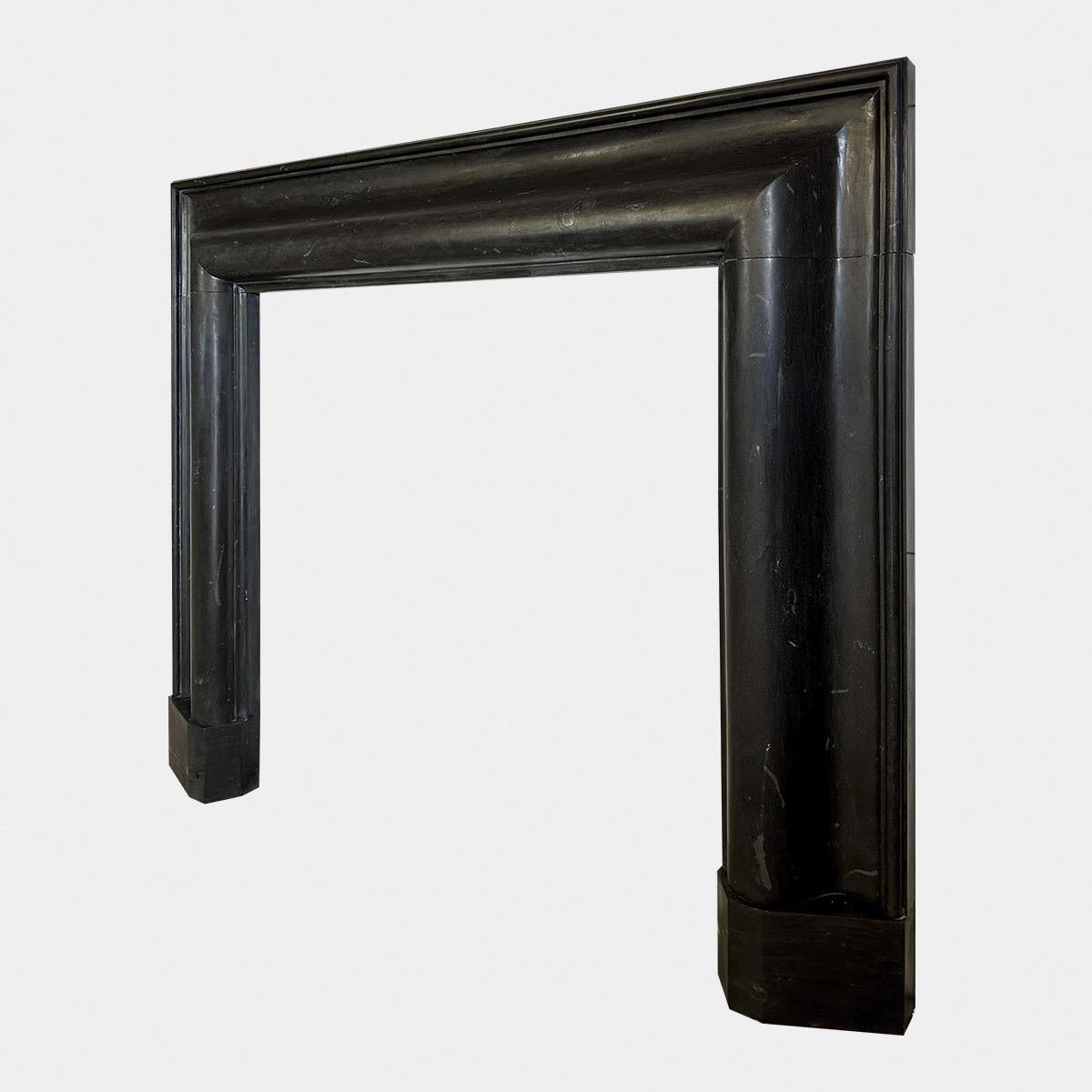 A large framed black Basalt stone bolection fireplace surround, with wide bolection moulding profile. Stood on shaped foot blockings. Almost jet black in colour with small inclusions as Basalt is a Volcanic rock. Incredibly hard and durable