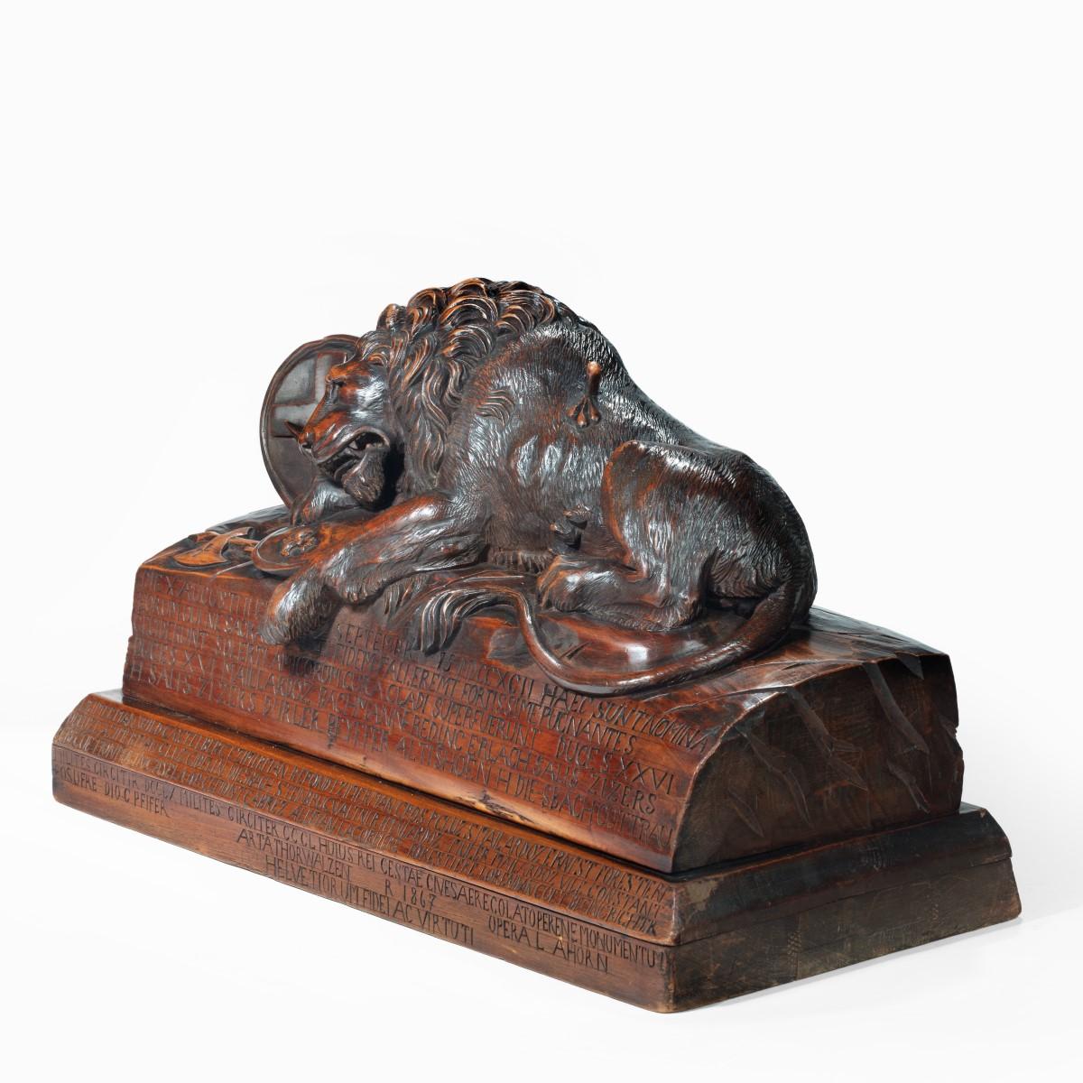 A large Black Forest model of the Lion of Lucerne dated 1867, after Bertel Thorvaldsen, carved from stained linden wood, the dying lion depicted beside two circular shields and an axe carved with crosses and fleurs de lys, set on a stepped base,