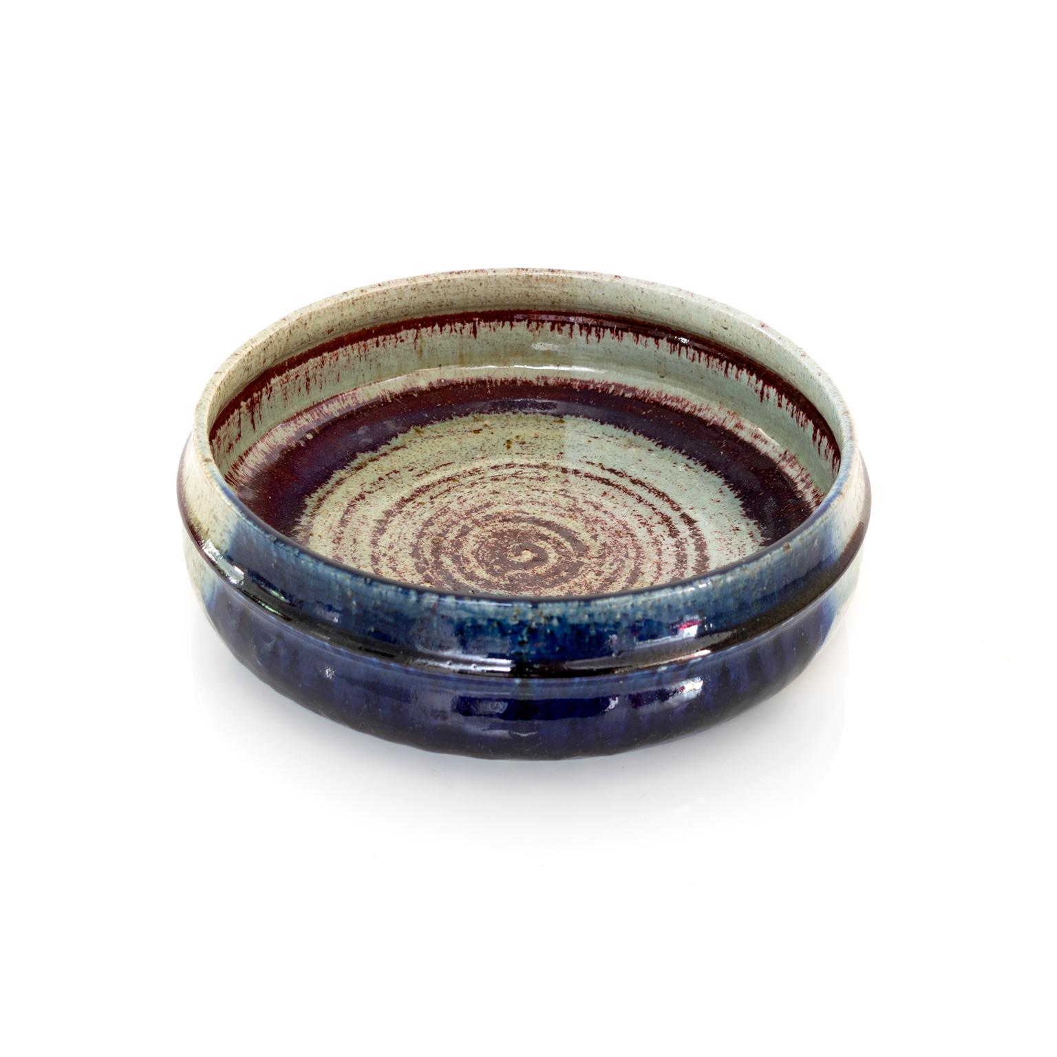 A large Rorstrand Studio ceramic bowl by Sylvia Leuchovious. This unique hand thrown bowl is glazed in deep blue and red against a lighter neutral base glaze. 

Measures: Diameter: 12