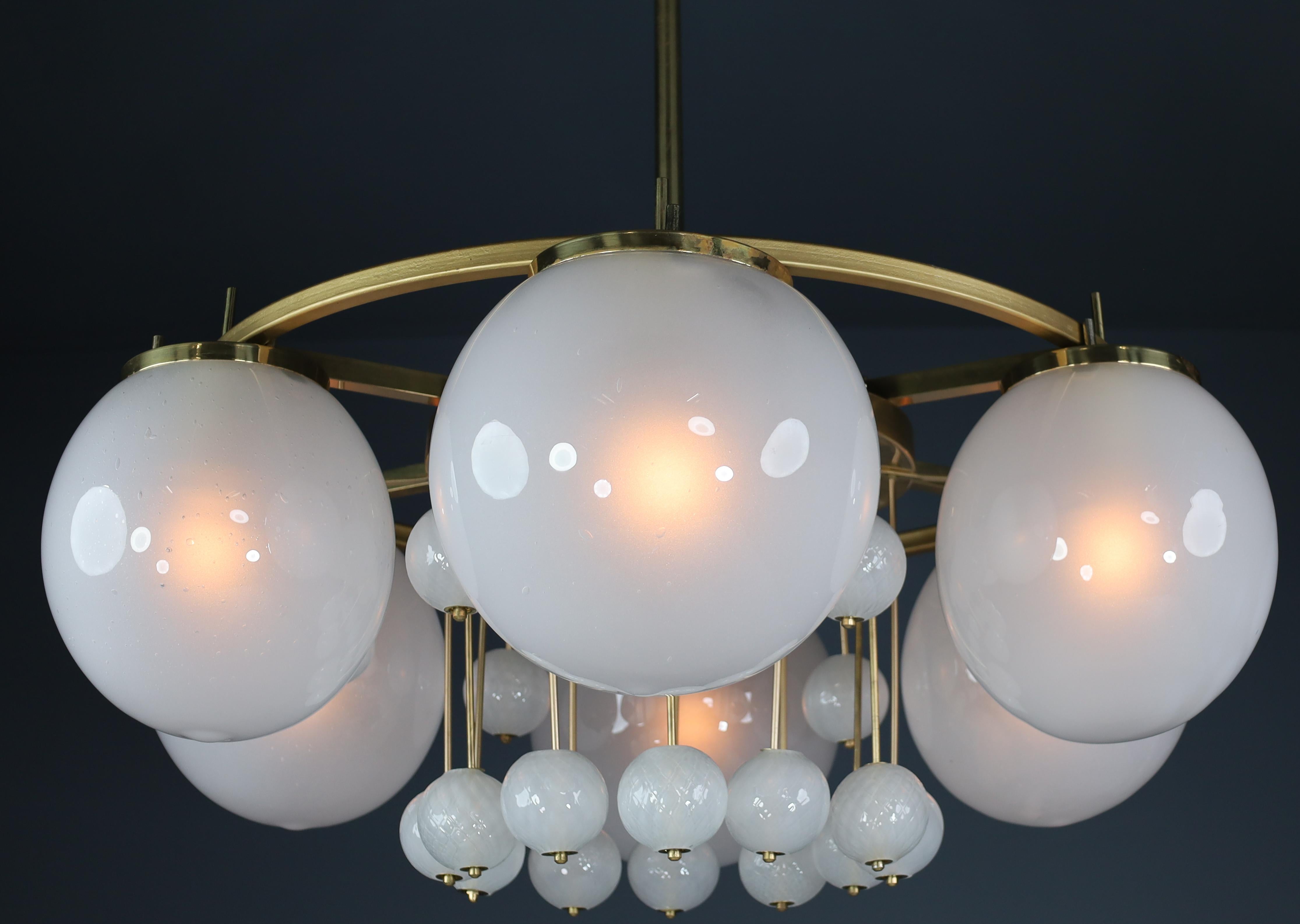 A large brass Bohemian chandelier with frosted glass globes, the 1950s

A magnific chandelier with brass fixture produced and designed in Czechia Bohemian in the 1950s. There are six large mouthblown, frosted glass globes, and 18 smaller