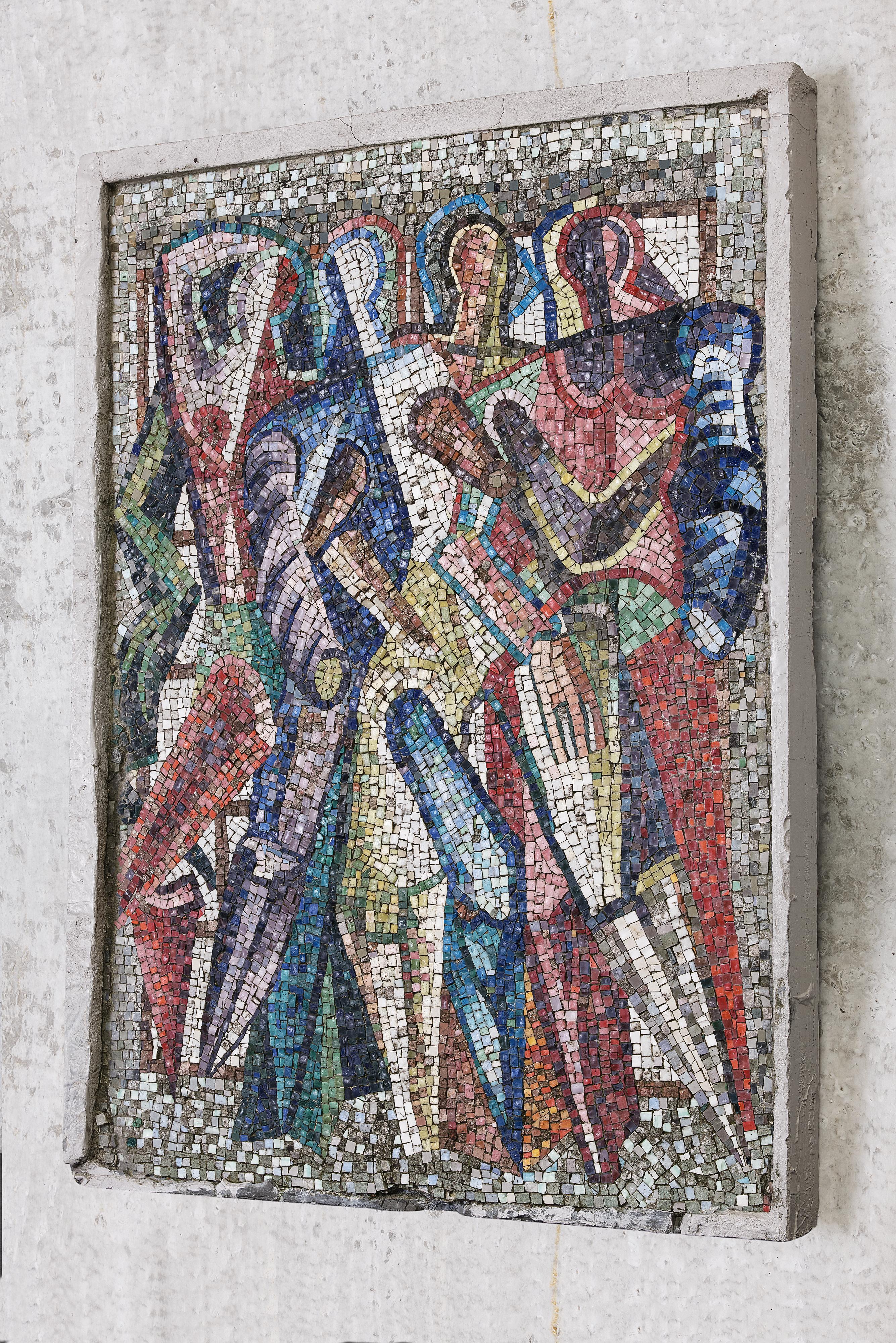 Ein großes, leuchtendes und farbenfrohes Mosaik aus mehreren abstrakten Figuren mit dem Titel 'Geweld' (Gewalt), eingebettet in einen Betonsockel. Es ist das Gegenstück zu einem anderen Wandgemälde mit dem Titel 