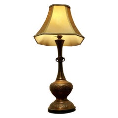 A Large Bulbous Embossed Copper Table Lamp