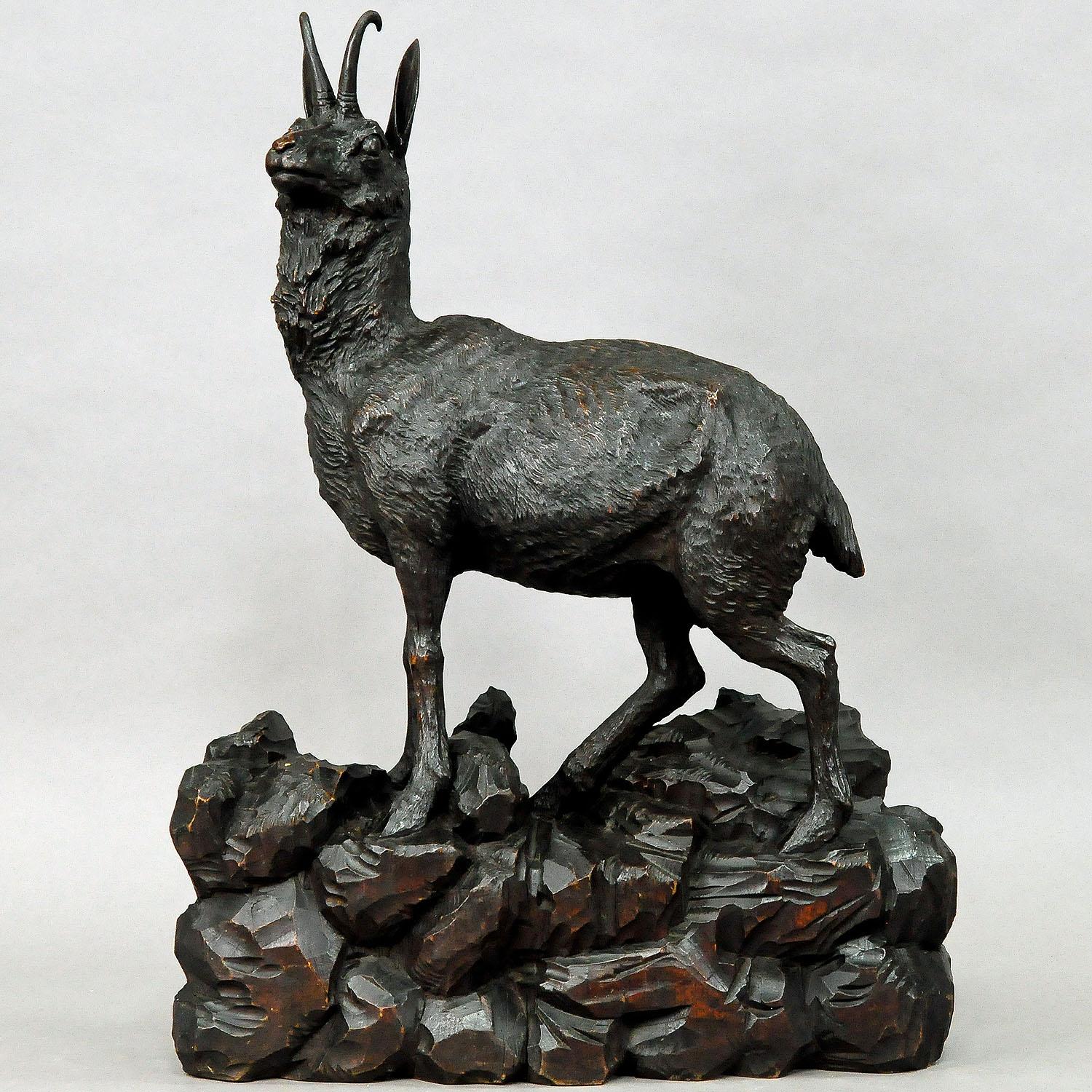 An expressive naturalistic carved large chamois sculpture standing on a rocky base. It is handcarved and stainied lindenwood. Executed in Austria around 1900.

Measures: Length 17.72