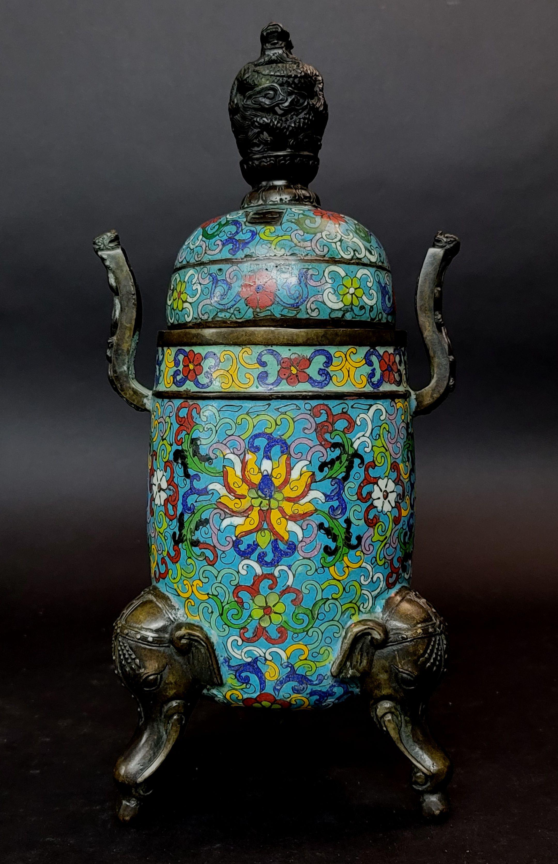 Chinese Cloisonne Tripod incense holder having bronze of 3 elephant heads form the feet, dragon form handles on two sides and a big dragon head finial, along with a removable, pierced cover, marked to the underside, overall height 14 inches.