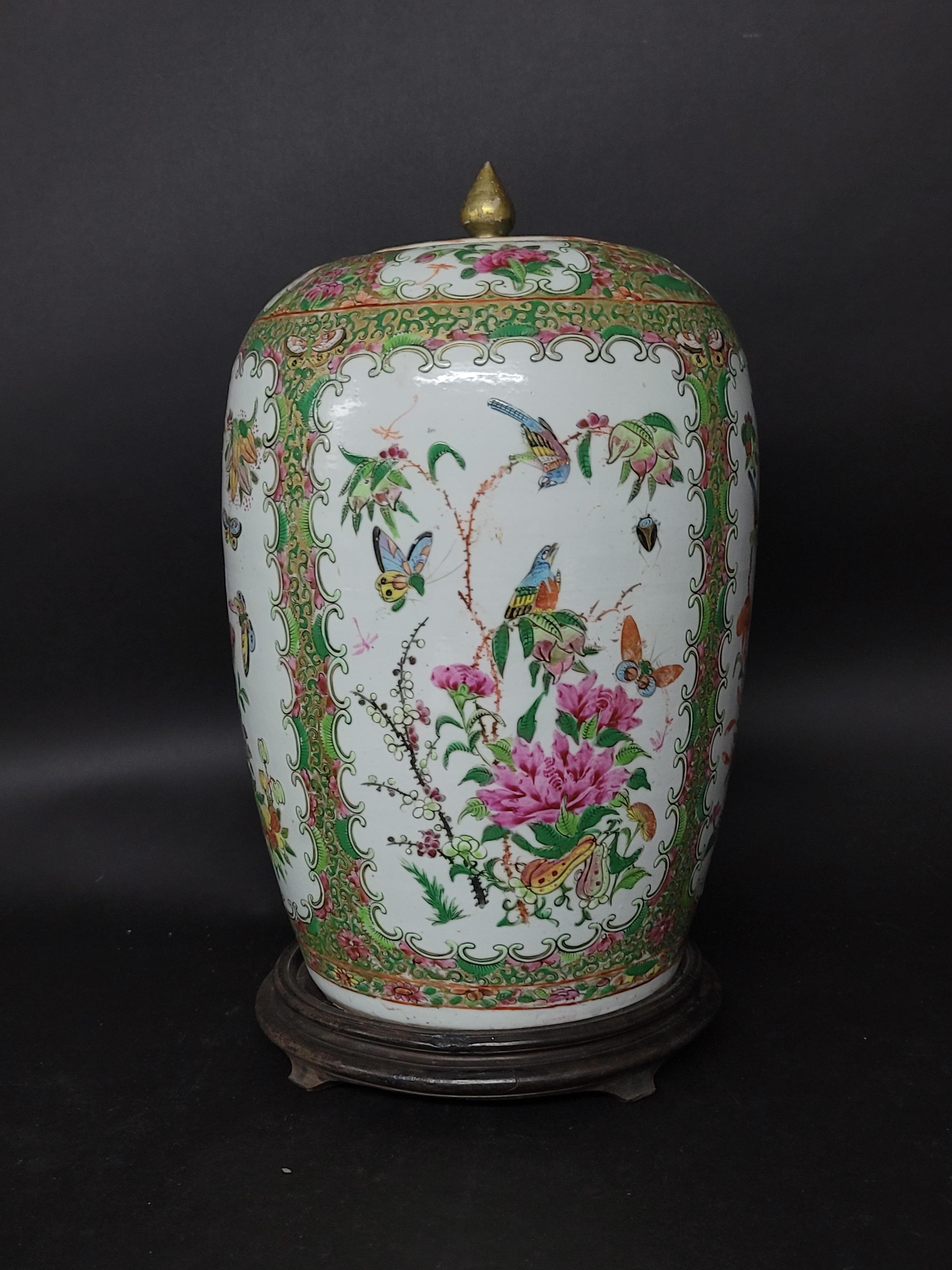 A large Chinese Export rose famille covered jar with wood base depicting birds and flower blossom.

    