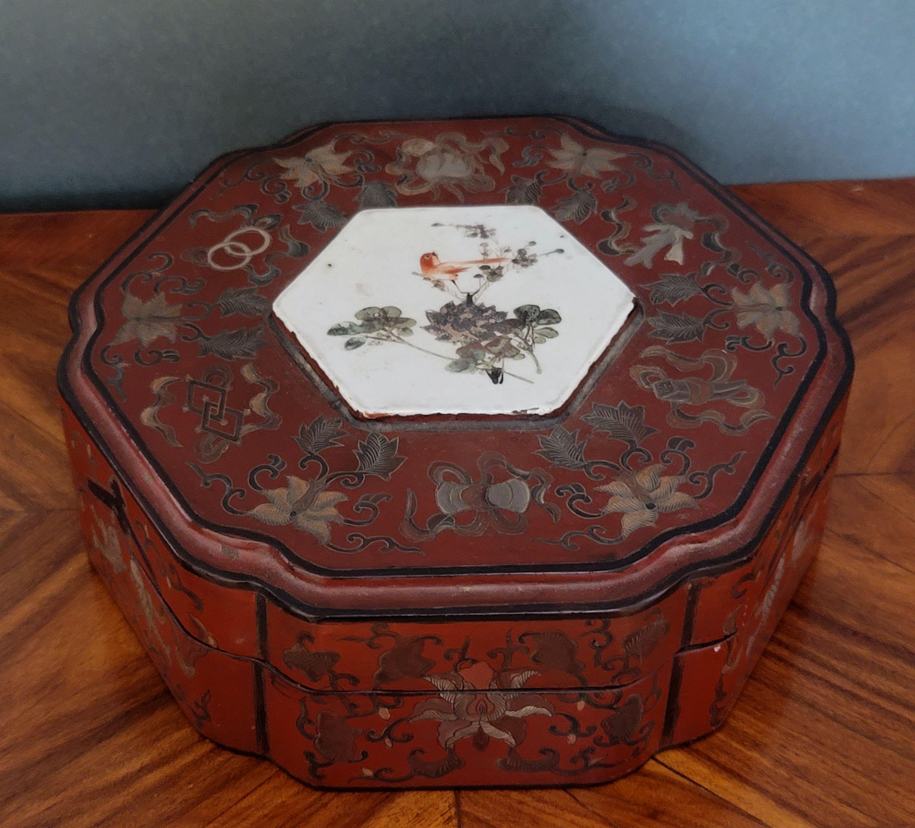 A large Chinese gilt lacquered box with porcelain medallion in the center top depicting floral pattern and bird.

 
