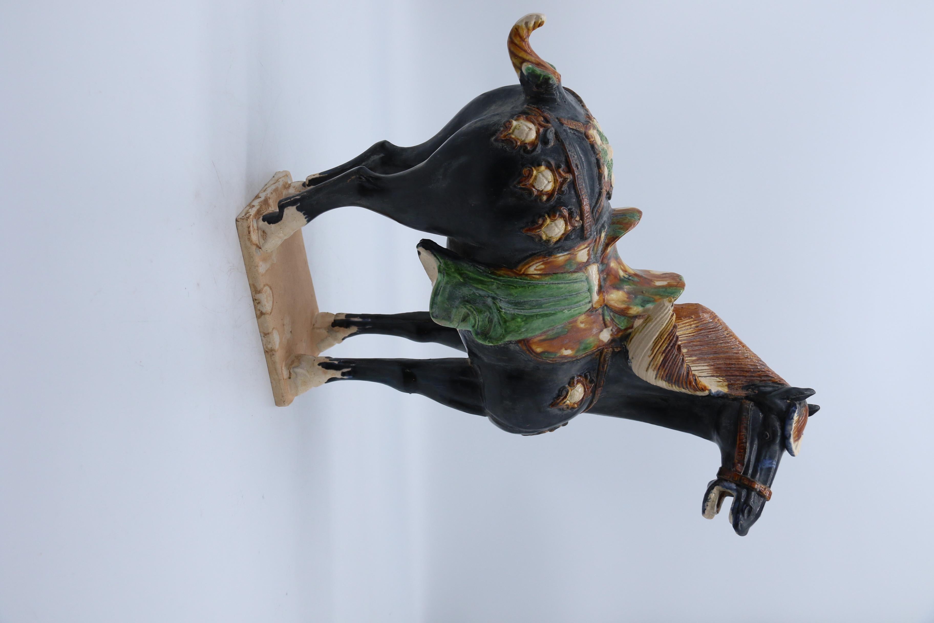 True in all its elements to the original examples which date from the early Chinese Tang period. The black glazed horse is naturalistically modelled. It stands on a rectangular base with a detailed mane, tail and hooves. The head is well defined