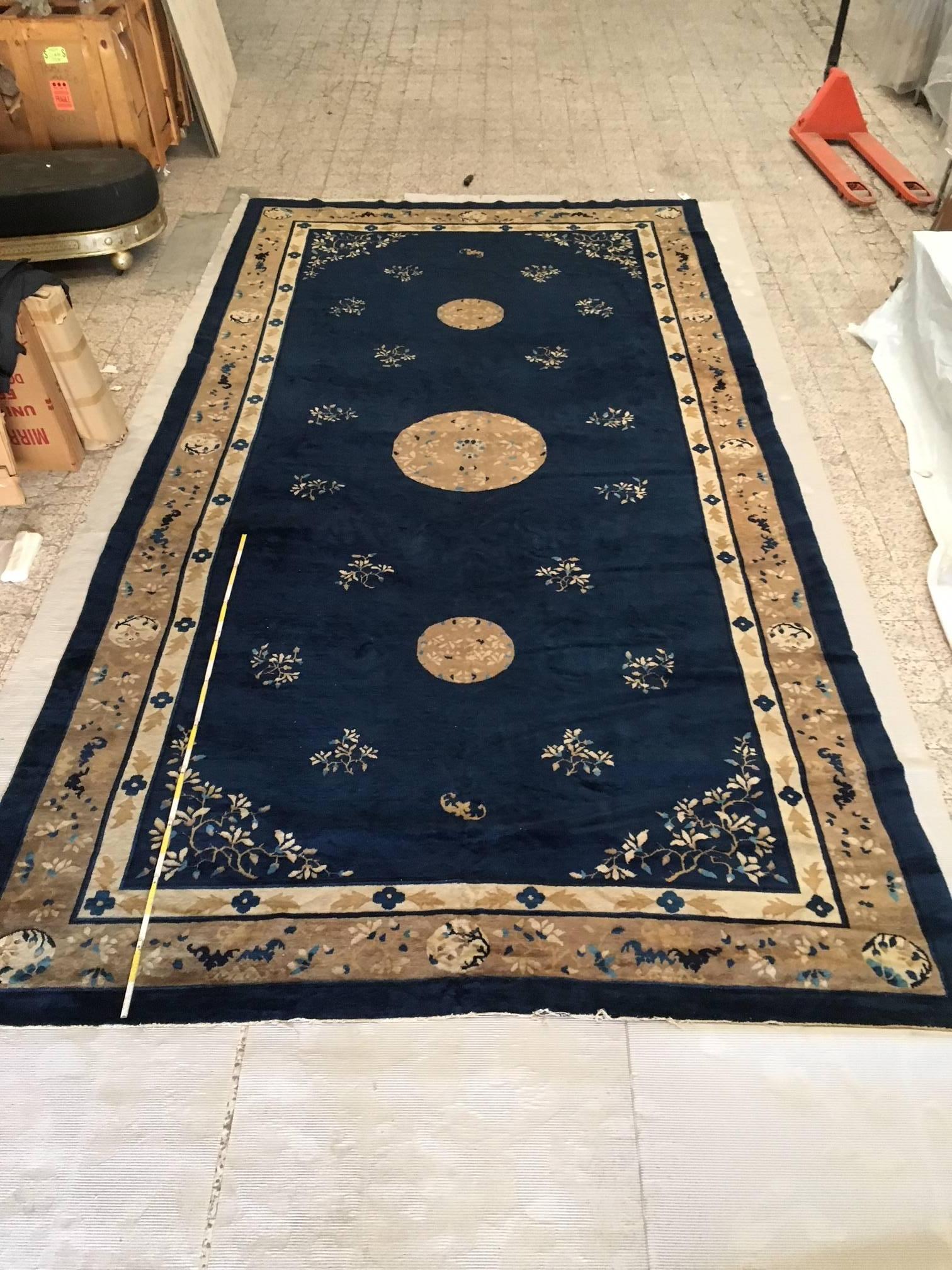 This massive, antique Peking rug features a complex yet traditional yet modern design that spreads across this composition. A simplistic design unfolds with elegance of this early 20th century Chinese Peking rug. From the all-over floral pattern to