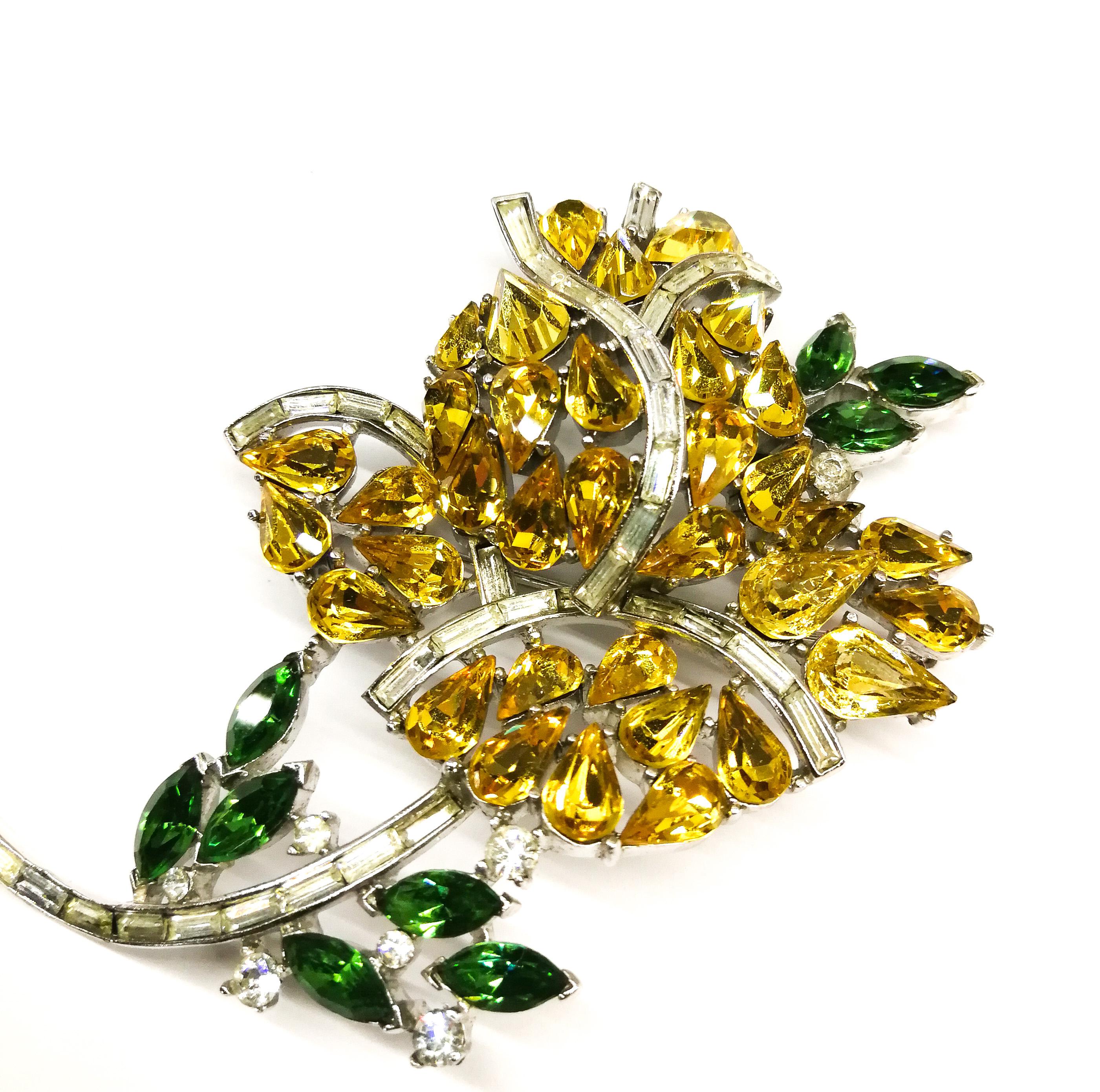 An exceptional and rare brooch, in the form of a flowering rose, by Alfred Philippe for Trifari. Hand set stones of citrine and emerald navette pastes, are delineated and highlighted by rows of clear paste baguettes, creating a very three