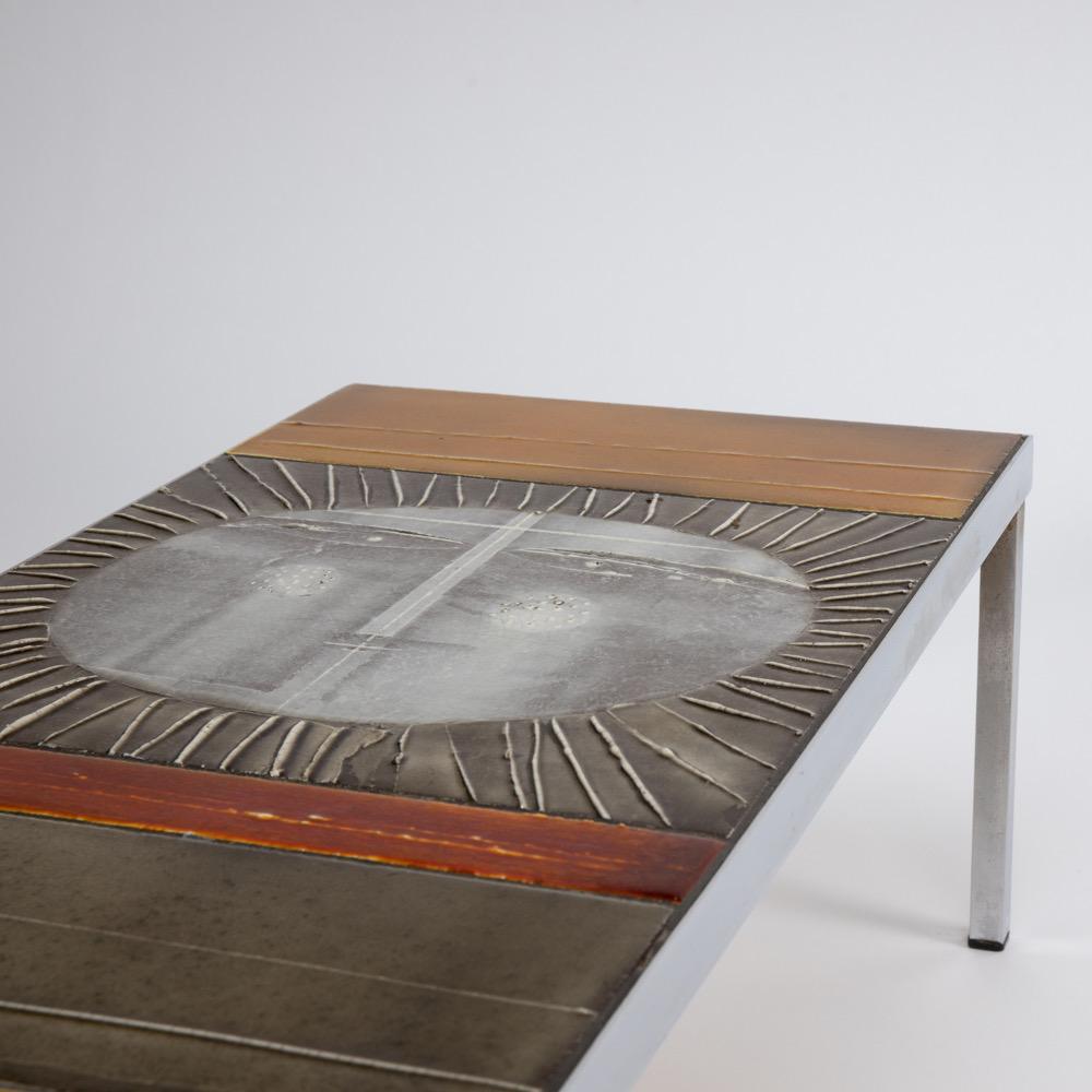 This emblematic low table is composed of a steel structure covered with colored earthenware tiles representing a sun in its upper part. It was manufactured in the sixties by the French master, Roger Capron, one of the best post-war ceramists.

Note