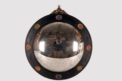 Un grande specchio convesso, cornice in legno, bronzo, pietre. Italia, inizio del XIX secolo.