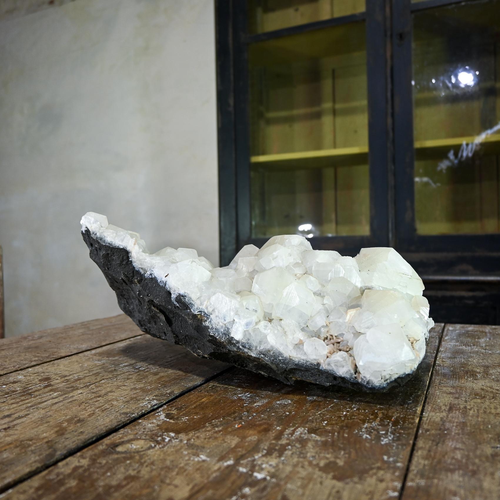 Presentare un consistente esemplare di fluorite Crystal Quartz Cluster è una testimonianza dell'incantevole bellezza delle formazioni rocciose naturali. Con un'impressionante larghezza di 46 cm, questo gruppo affascina con la sua intricata