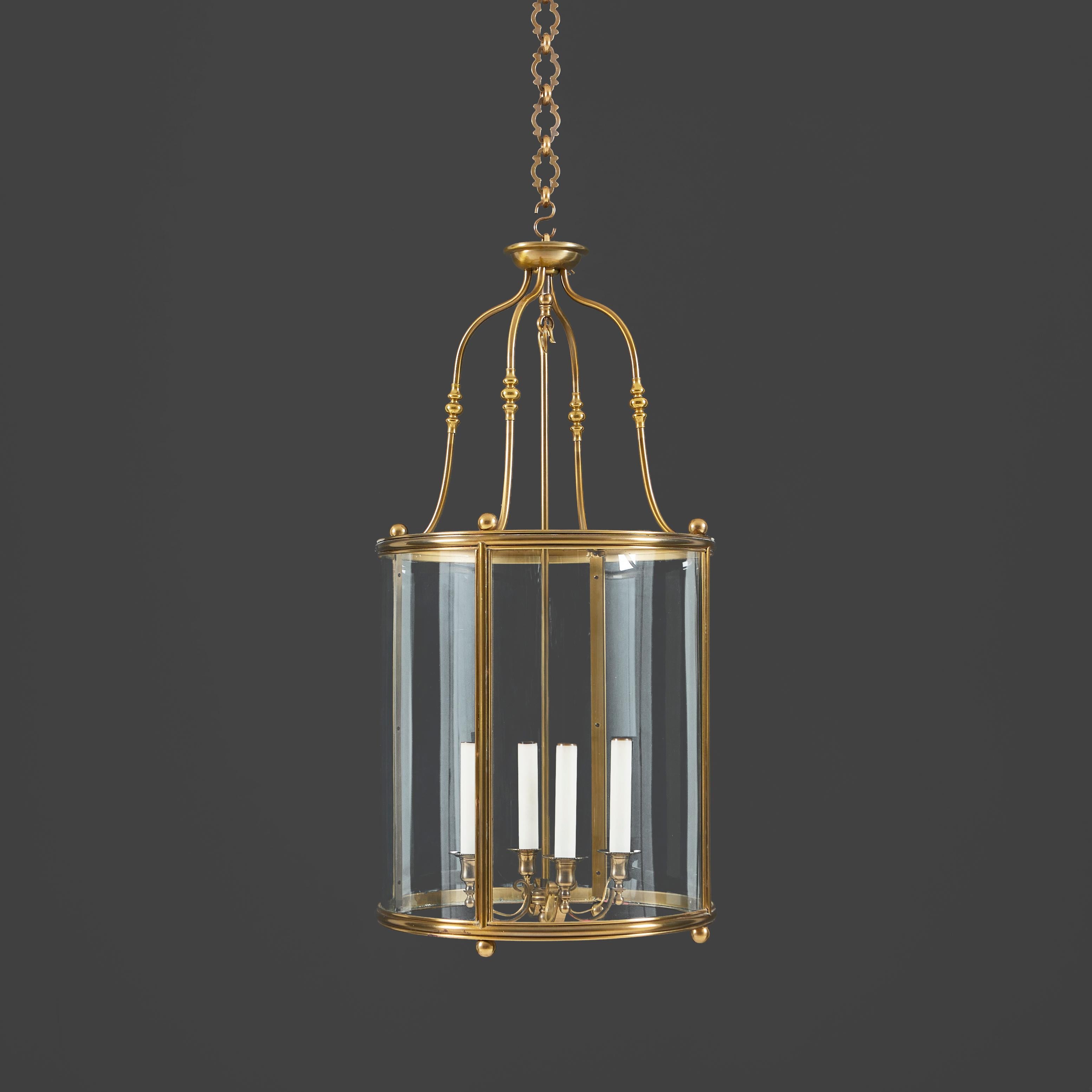 France, circa 1900

A late nineteenth century - early twentieth century cylindrical brass hall lantern of large scale, of Neoclassical form, with brass ball finials throughout, with curved glass panels, with a four arm chandelier element. 

Height