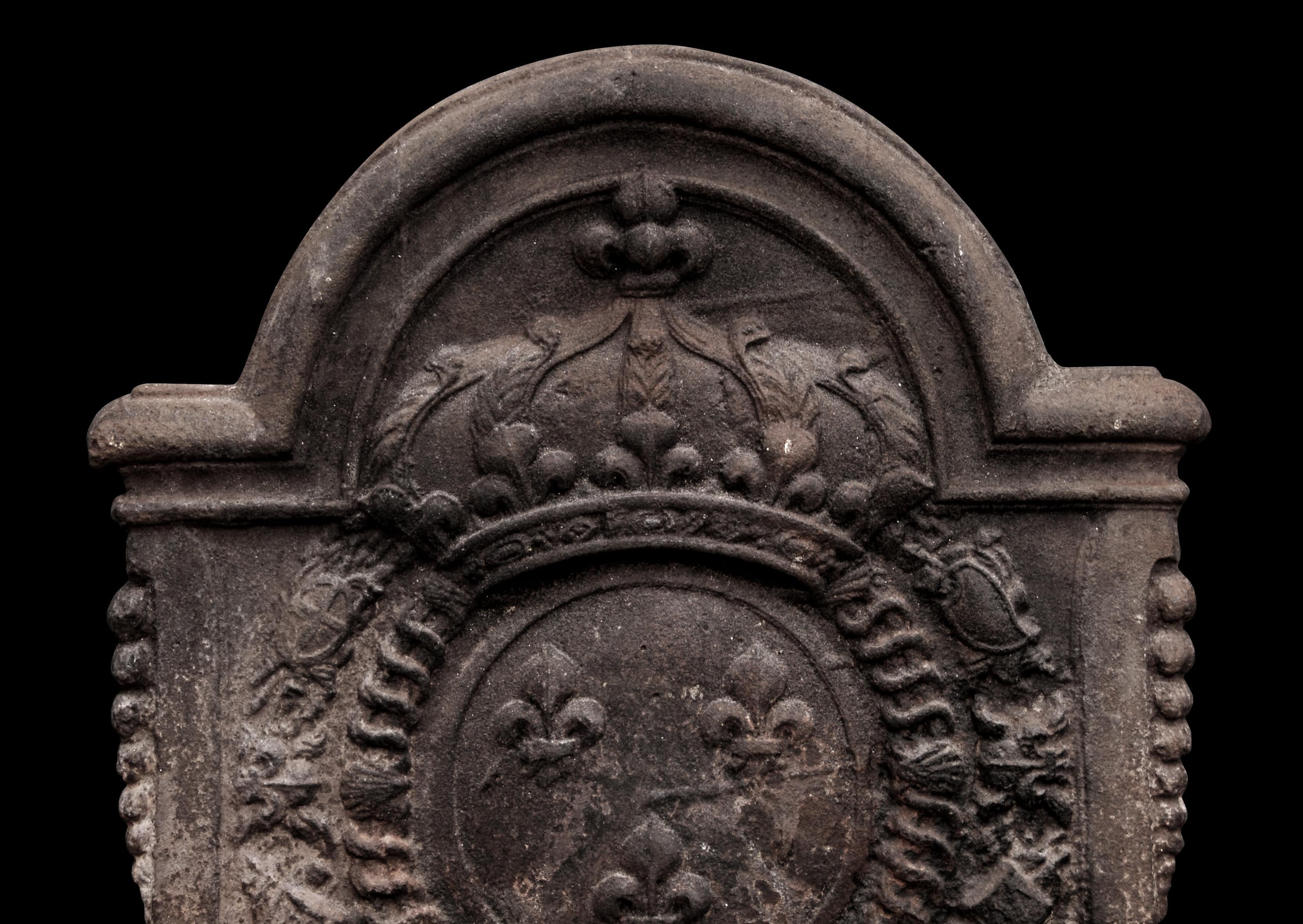 A shaped 19th century cast iron fireback. The circular centre tablet with fleurs-de-lys pattern surmounted by crown above. (Currently in weathered condition but could equally be cleaned and blacked if required.)

Height:	806 mm      	31