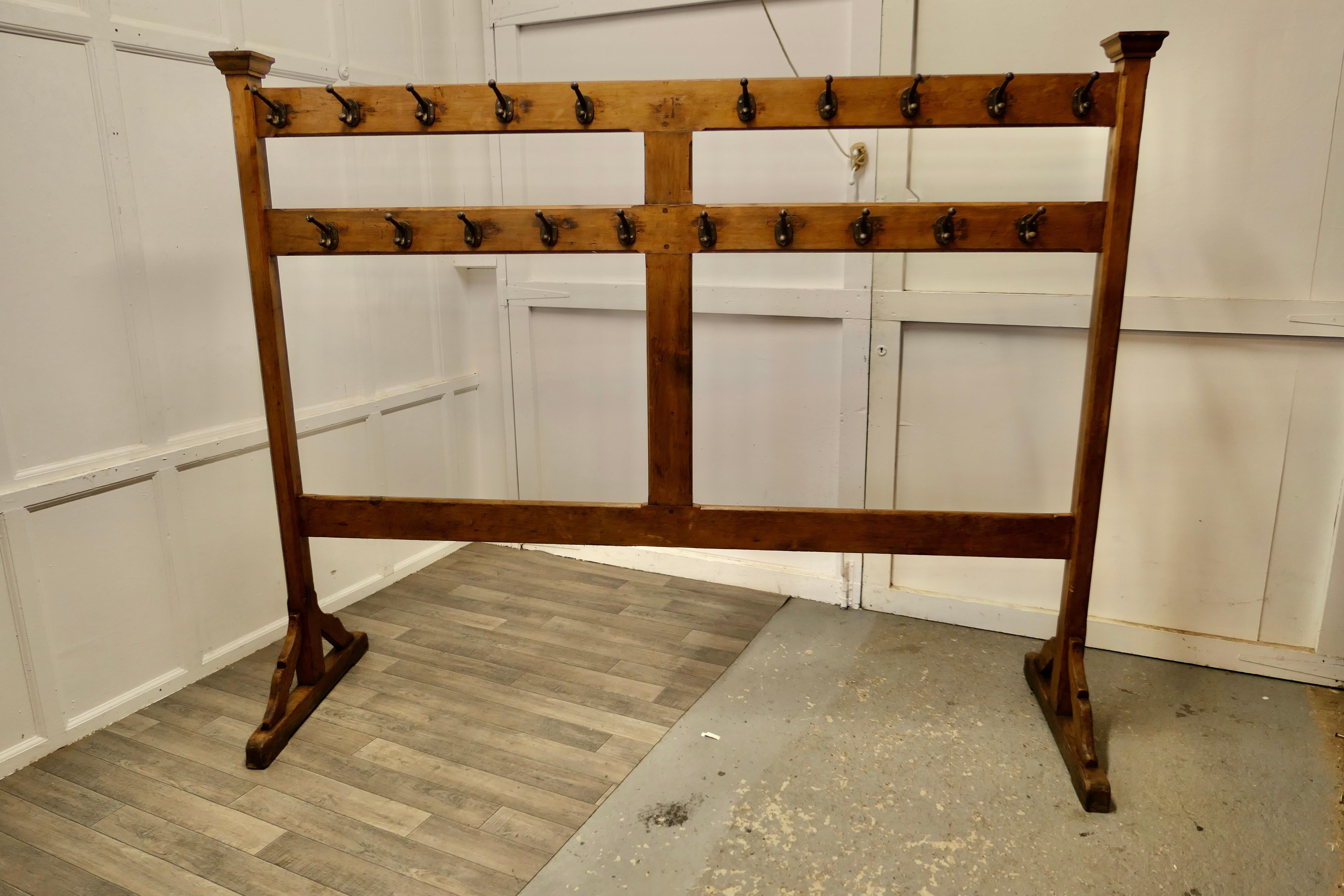 A large double sided Arts & Crafts golden pine clothes rail 

The Cloakroom Rail is a College Gymnasium piece it has a total of 40 double iron clothes hooks, the frame is made in Golden Pitch Pine 
The wood is chamfered in the Arts and Crafts