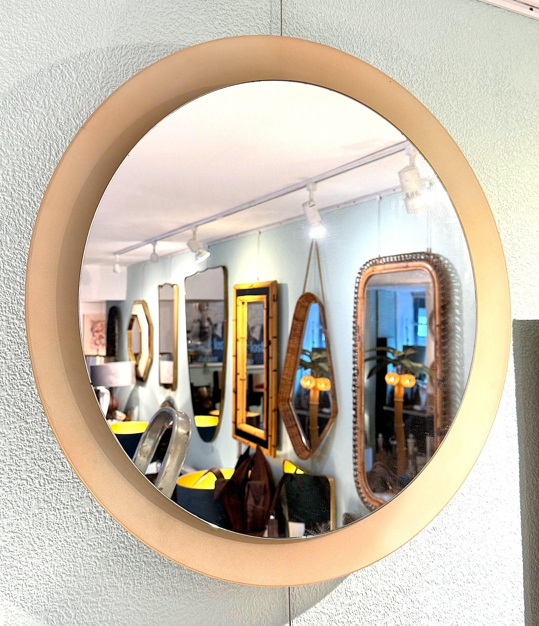 A large circular mirror in the Style of Max Ingrand with a concave dusty pink back and frame surround, around a central circular mirror. It could be backlit to create a a wonderful glow through the pink.