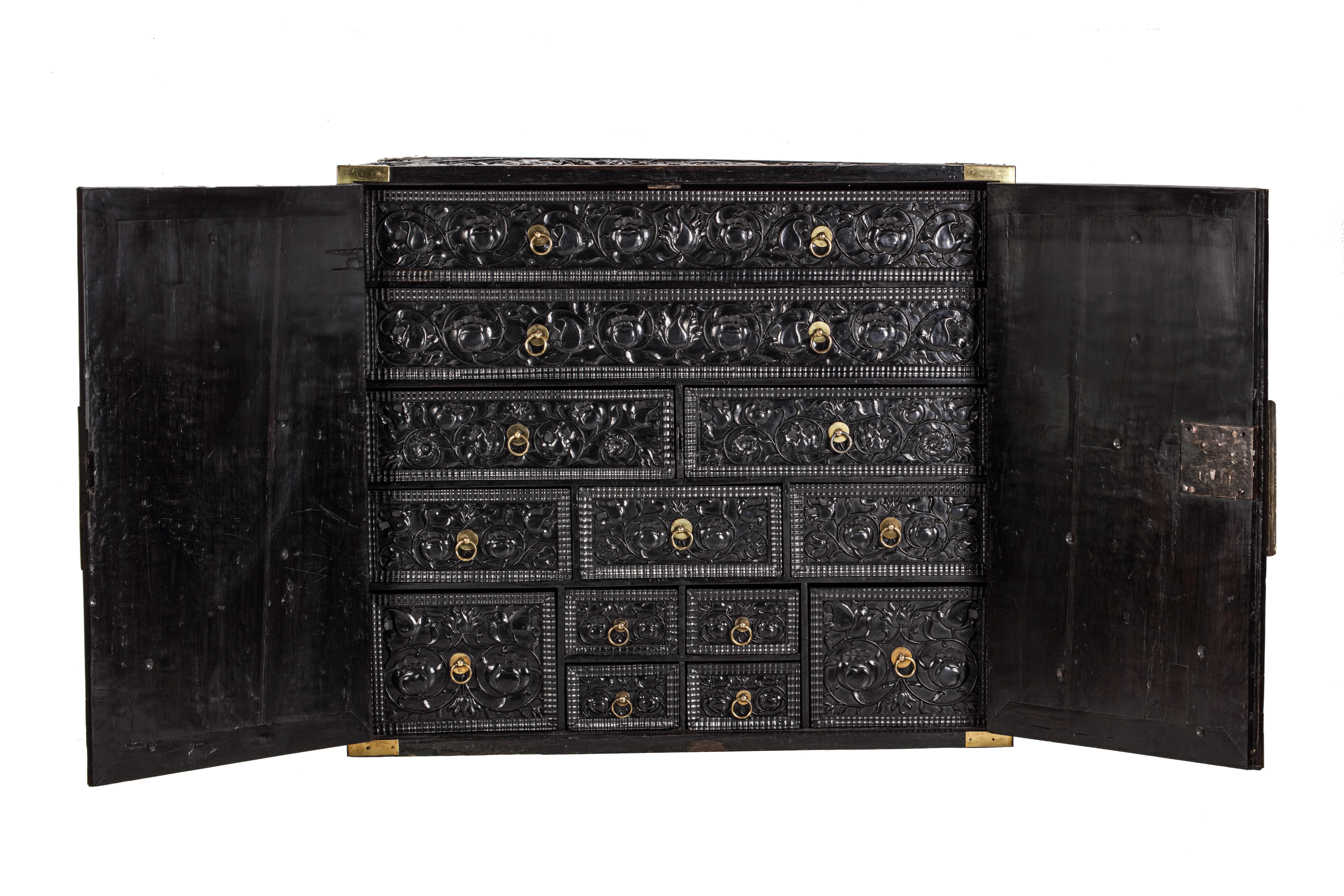 A Dutch colonial ebony cabinet with brass mounts on contemporary black steel frame

Batavia (Jakarta), 2nd half 17th century

The cabinet has two massive ebony doors opening to reveal thirteen various-sized drawers. The outside of the cabinet and