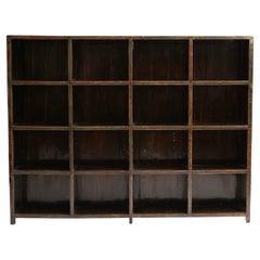 A large early 20th-century elm wood bookcase from China, this piece features 16 