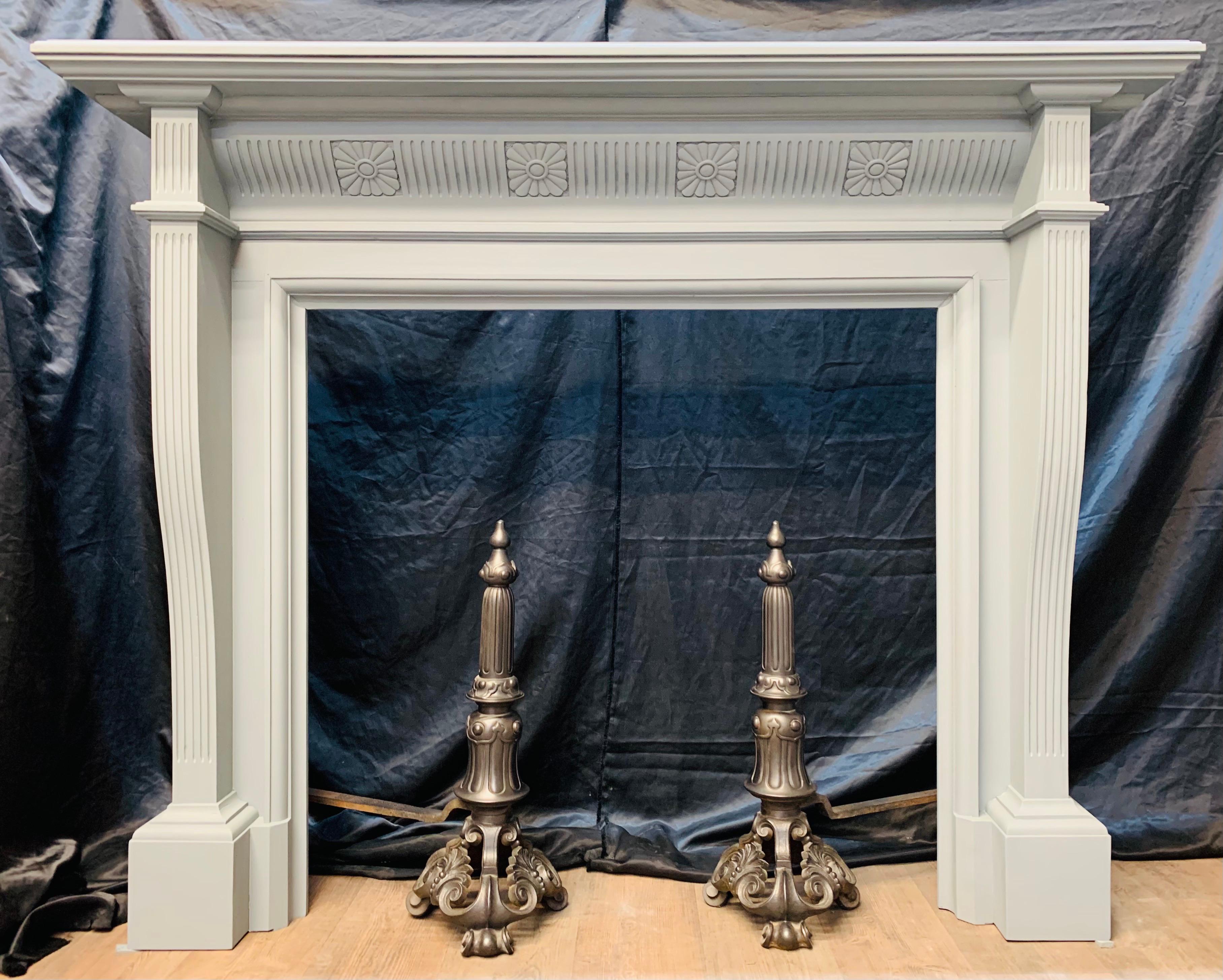 A large antique solid oak fireplace surround from the early Edwardian period displaying handsome proportions primed French grey. A substantial double thickness moulded shelf above a shaped frieze with clasps of vertical flutes and intermittent
