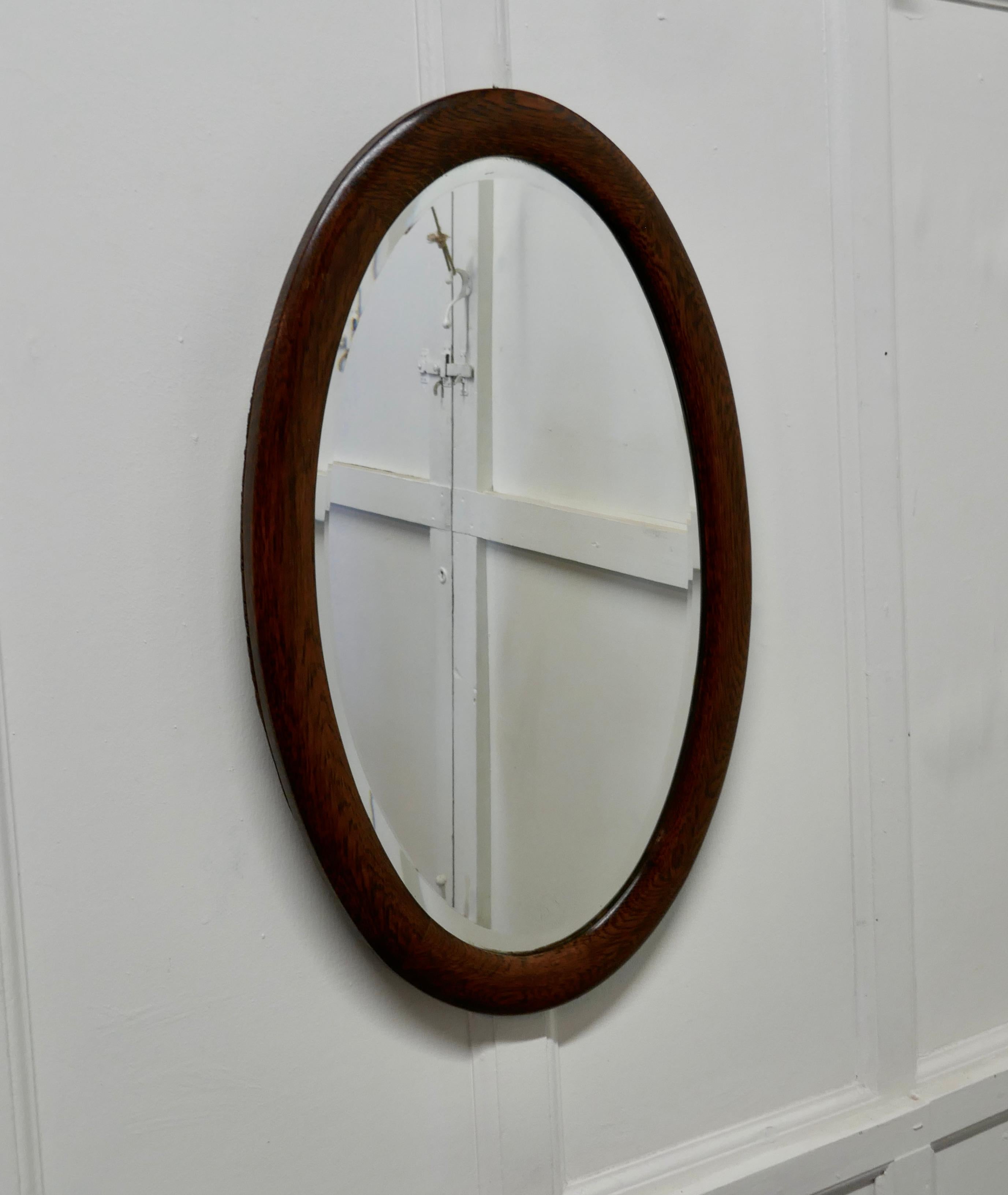 A large Edwardian oak oval mirror

This mirror has a 2” wide moulded oval oak frame 
The large oval frame is in very good condition as is the original oval bevelled looking glass, with only very minor foxing
The mirror is 18” wide and 29” tall