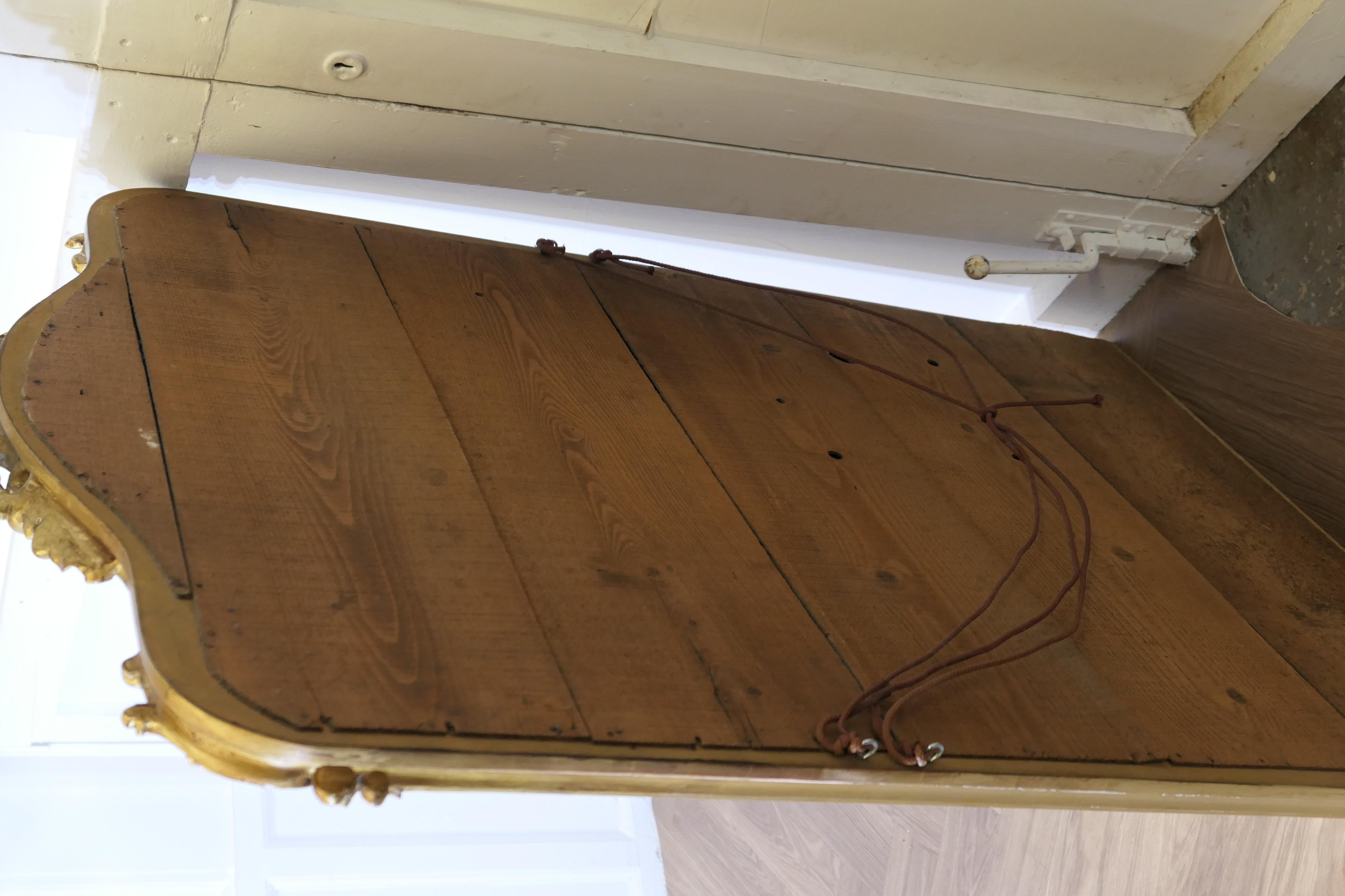 Gesso A Large Elaborate French Rococo Gilt Console Mirror Decorated with Scrolls For Sale