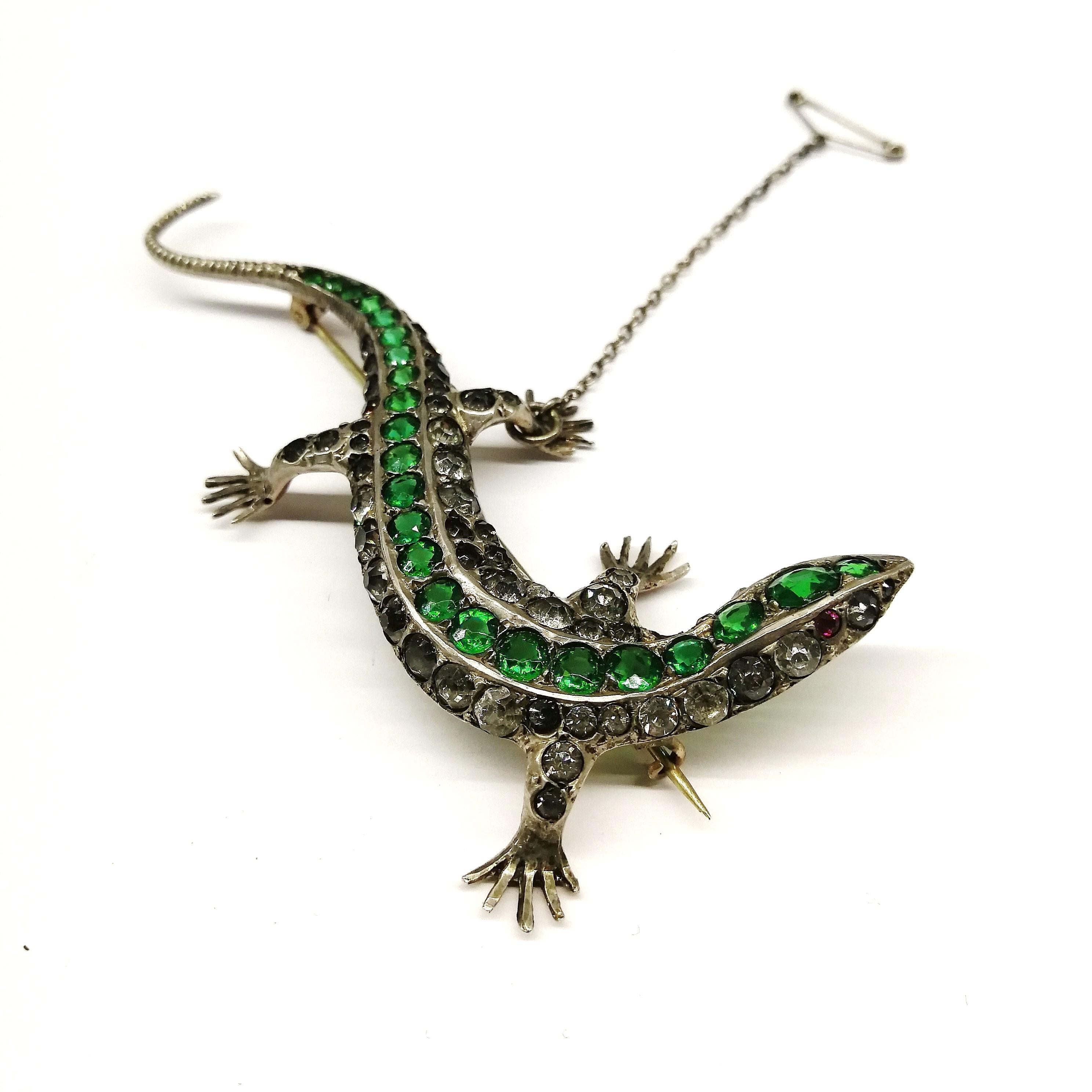 A large striking sterling silver 'lizard' brooch, in serpentine form, set with old cut emerald and clear pastes, and a ruby paste 'eye', from the early 1900s. it is most probably made in England. It is softly gilded on the reverse, whist the front