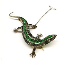 A large emerald and clear paste 'lizard' brooch, c 1900.