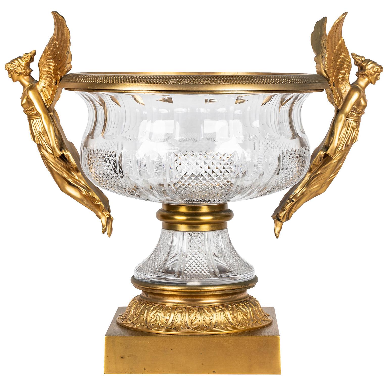 A Large and Impressive French Empire Revival Style Gilt-Bronze and Cut-Glass 'Grande Coupe' Figural Urn Centerpiece, in the manner of Baccarat, the mounts in the manner of and after Pierre-Philippe Thomire (French, 1751-1843). The two-part ovoid