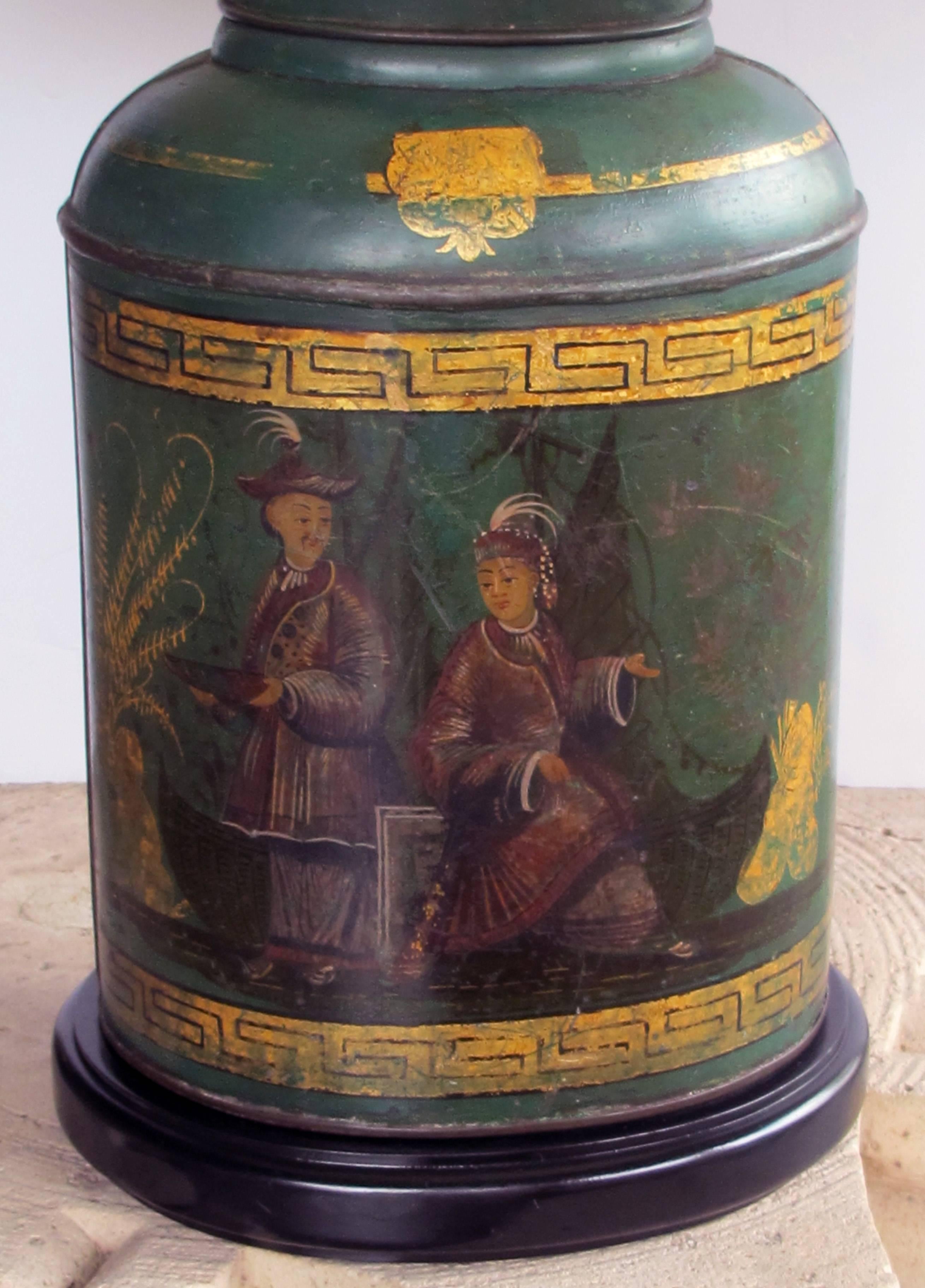 A well-executed and large-scaled English antique Bartlett & Son Japanned tole tea canister now mounted as a lamp; this good example of an antique tole tea canister of oval cylindrical form with Japanned decoration on a green ground enclosed by