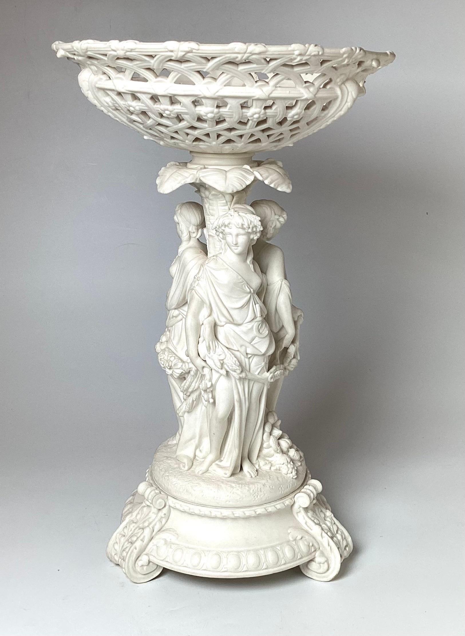 Elegant English porcelain bisque tall pedestal center bowl depicting the tree graces.  The reticulated bowl with the center of the three graces on a round footed base.  Attributed to Minton.