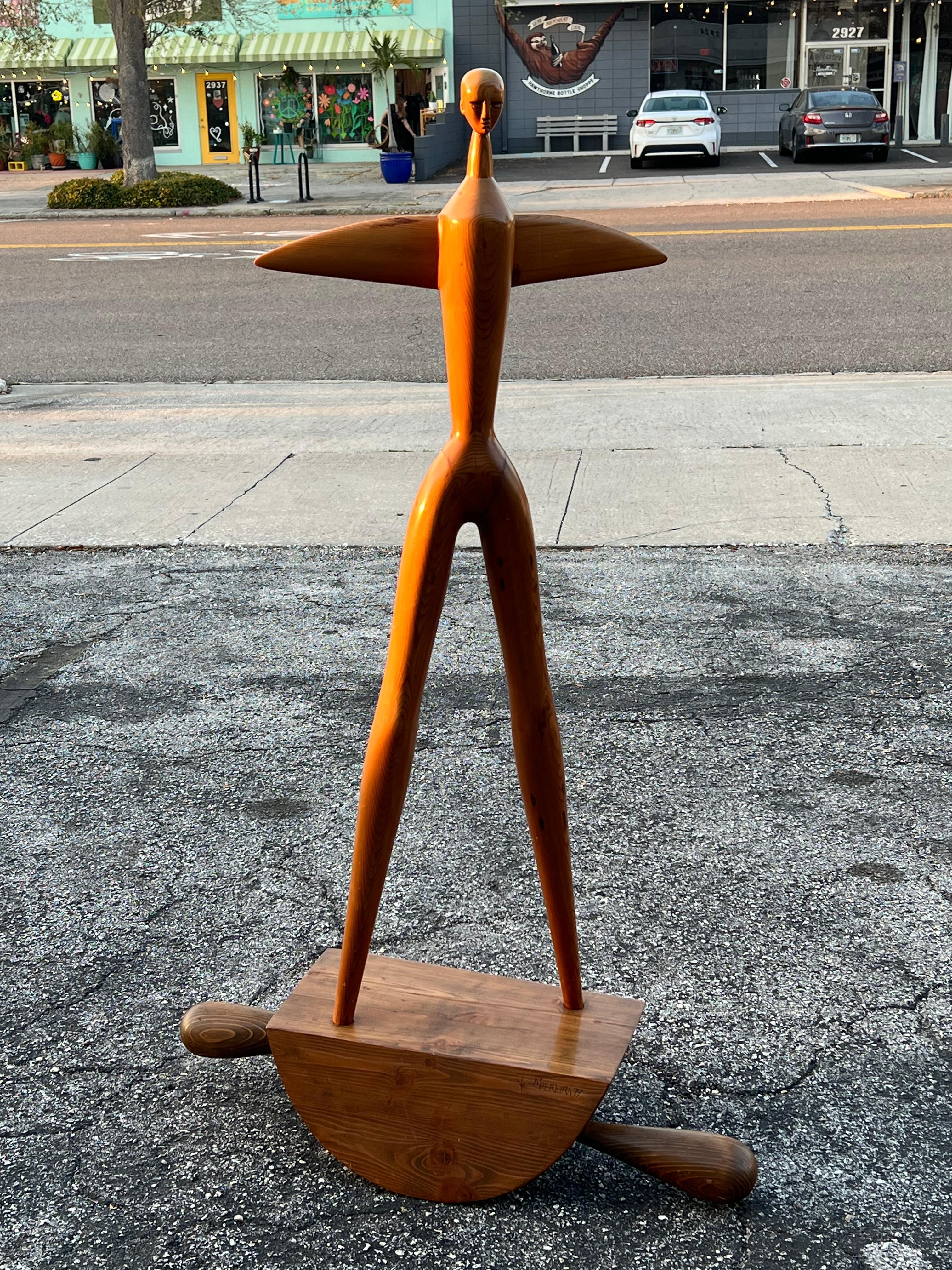 Una escultura de hombre estilizada y muy poco habitual, obra del escultor portugués Manuel Pereira da Silva. De pino, 1979. 
Una nota sobre el artista: 