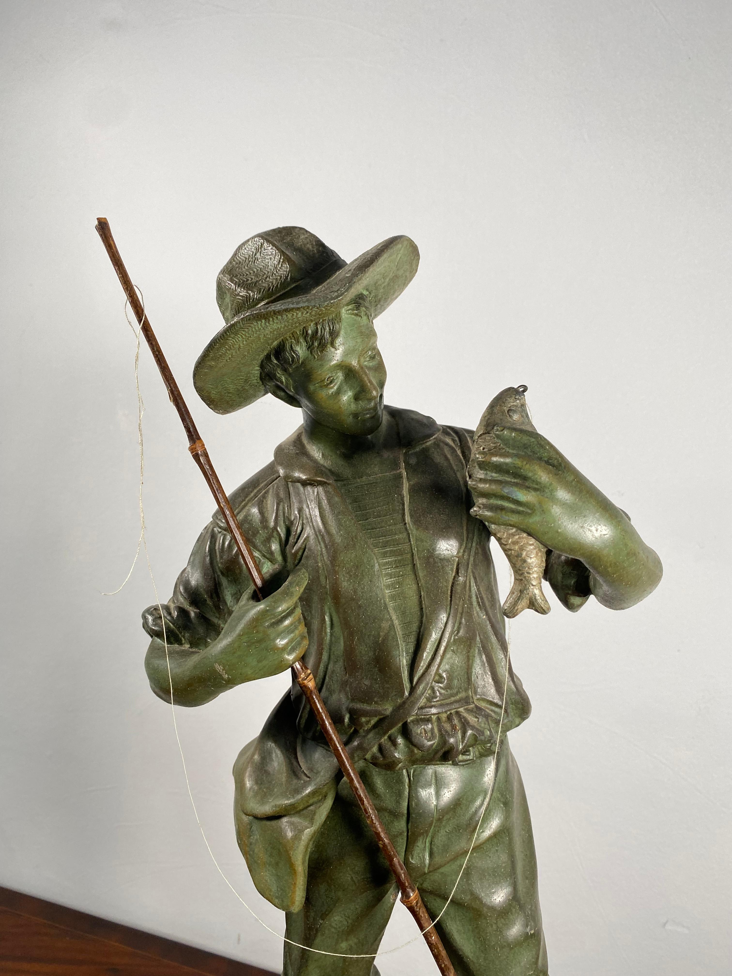 A fantastic bronze depicting a young fisherman proudly holding a trout that he has caught.