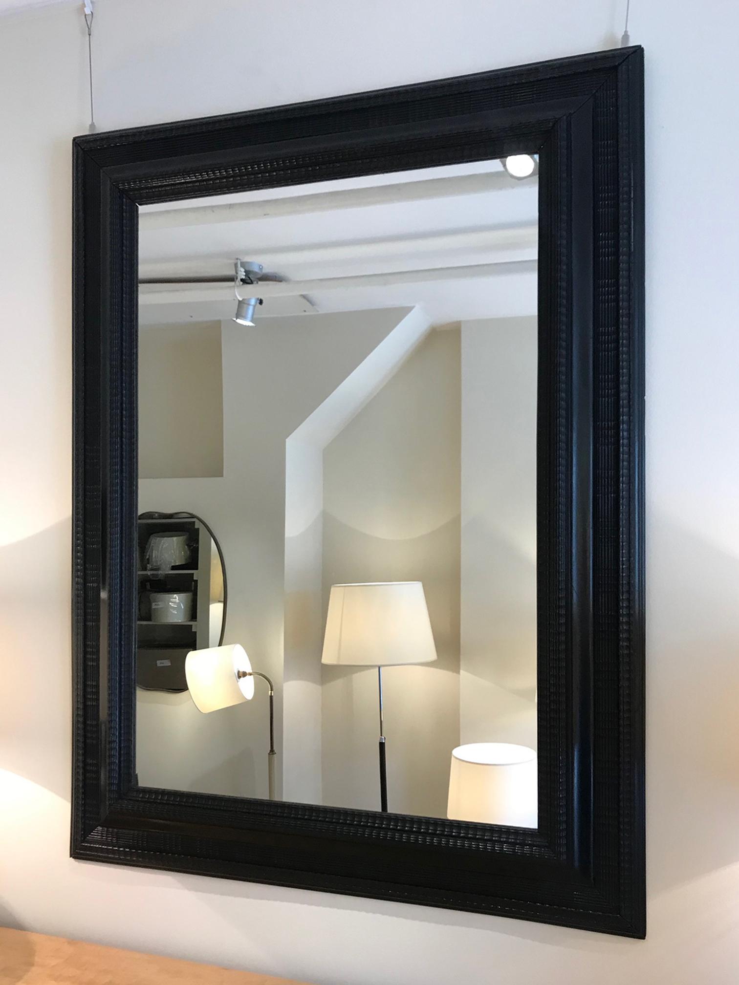 A large Flemish ebonised carved wood ripple frame mirror
Holland, circa 1920.