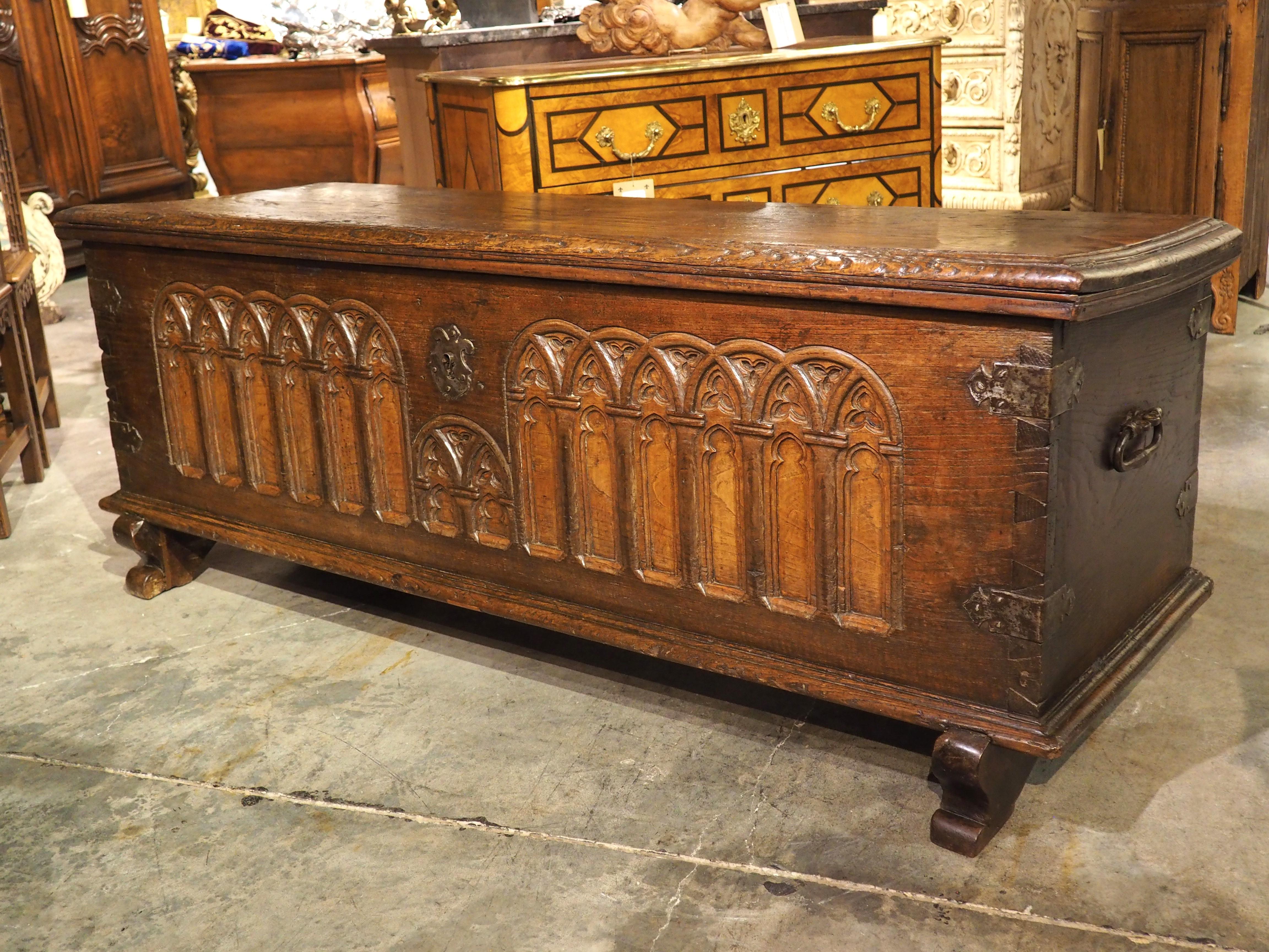 A beautiful display of French craftsmanship, this large Gothic-style trunk was hand-carved in the 1600s from chestnut. The highly detailed front façade features multiple sections of arcading, complete with niches supported by colonnades and filled