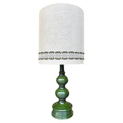 A large French 1960s green glazed ceramic lamp with original hessian shade