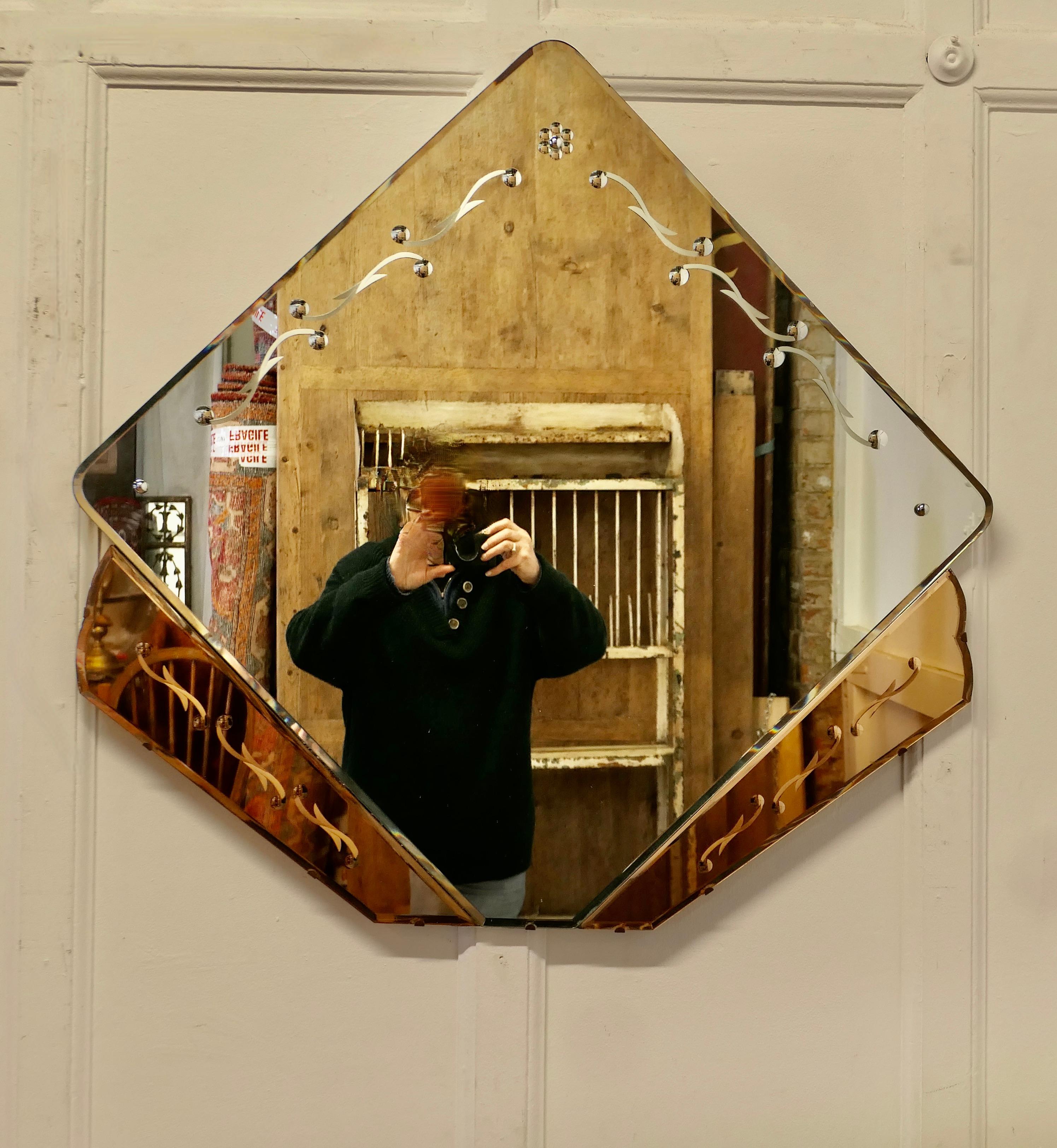 A Large French Art Deco Diamond Wall Mirror

This is a very unusual piece it has a central square mirror set as a diamond shape in a Peach base, the glass is bevelled and etched 
This is a classic and stylish piece it is in very good condition with