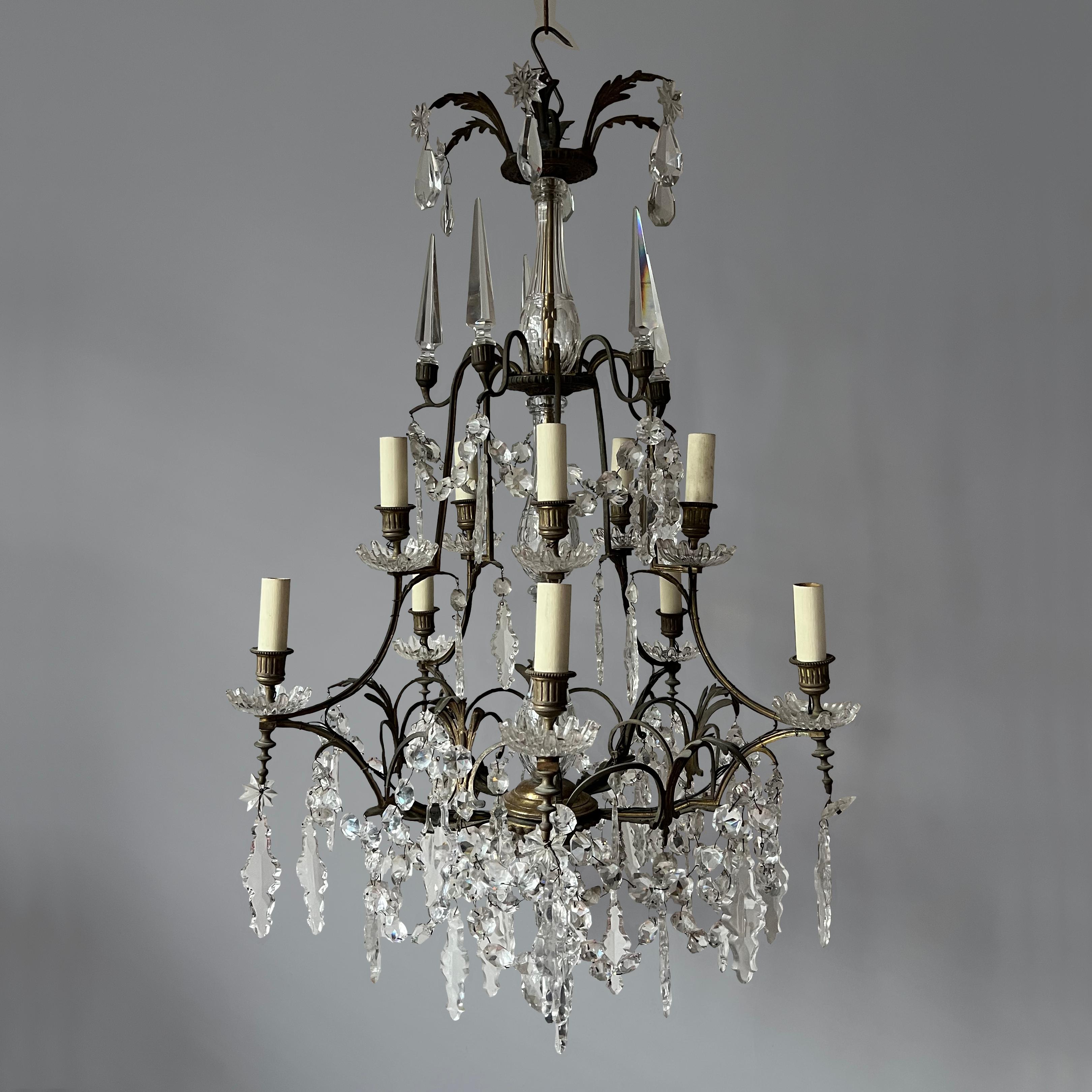Elegante lampadario francese dell'inizio del XX secolo con obelischi in cristallo tagliato e gocce piatte a forma di pera in vetro tagliato unite a festoni di perline sfaccettate, con stelle in vetro tagliato e terminanti con un finale a sfera in