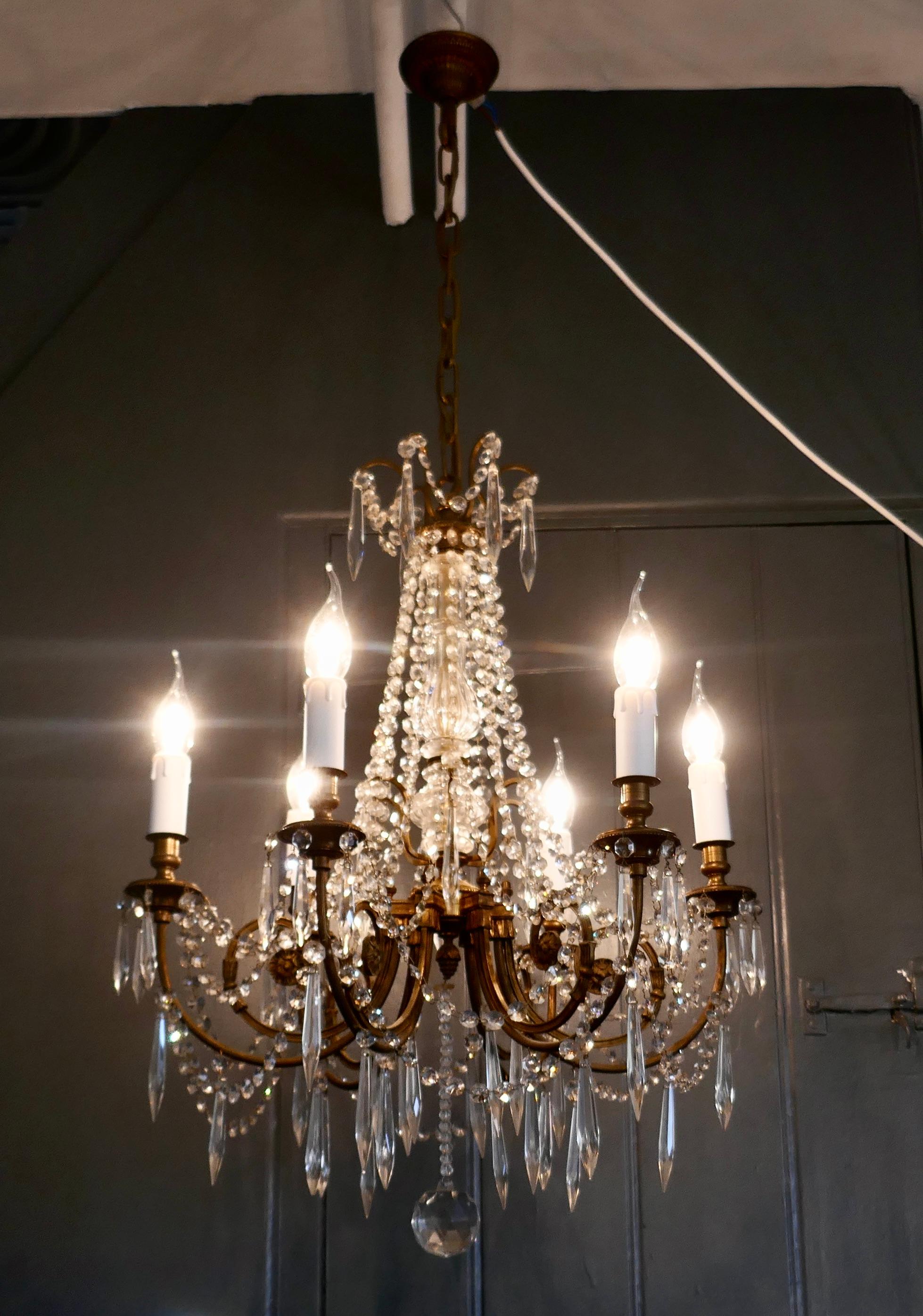 A large French crystal 6 branch salon chandelier

This is a superb French chandelier, the brass arms and sconces have a gilt finish, The light is hung with long chains and pendants
There is a further layer of lustres around the brass chain at the
