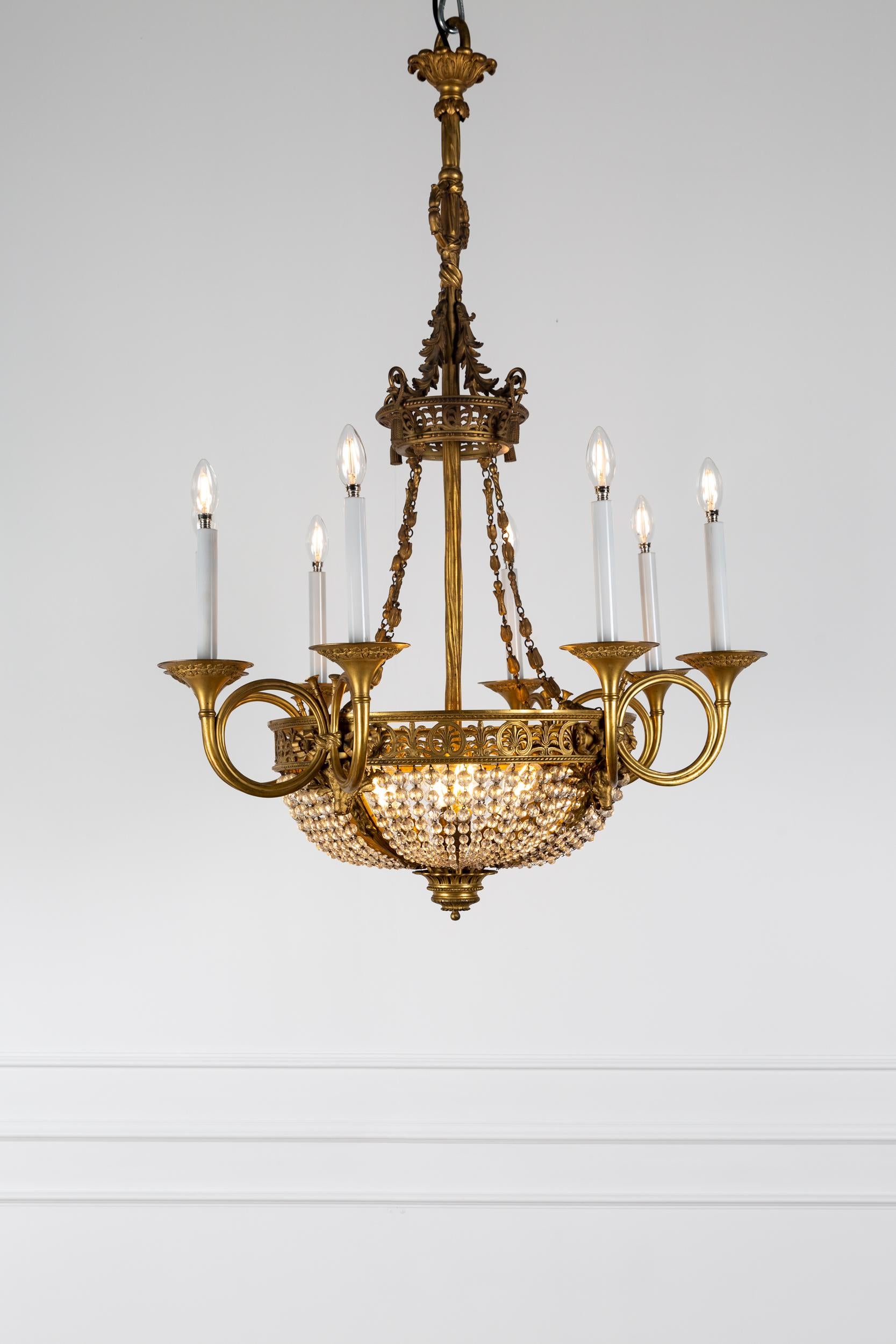 An impressive large French directoire period bronze and crystal twelve light chandelier dated to late 18th century.

Top crown or corona features a smaller version of the main band with palmette decorative head, foliate and tassel drapery