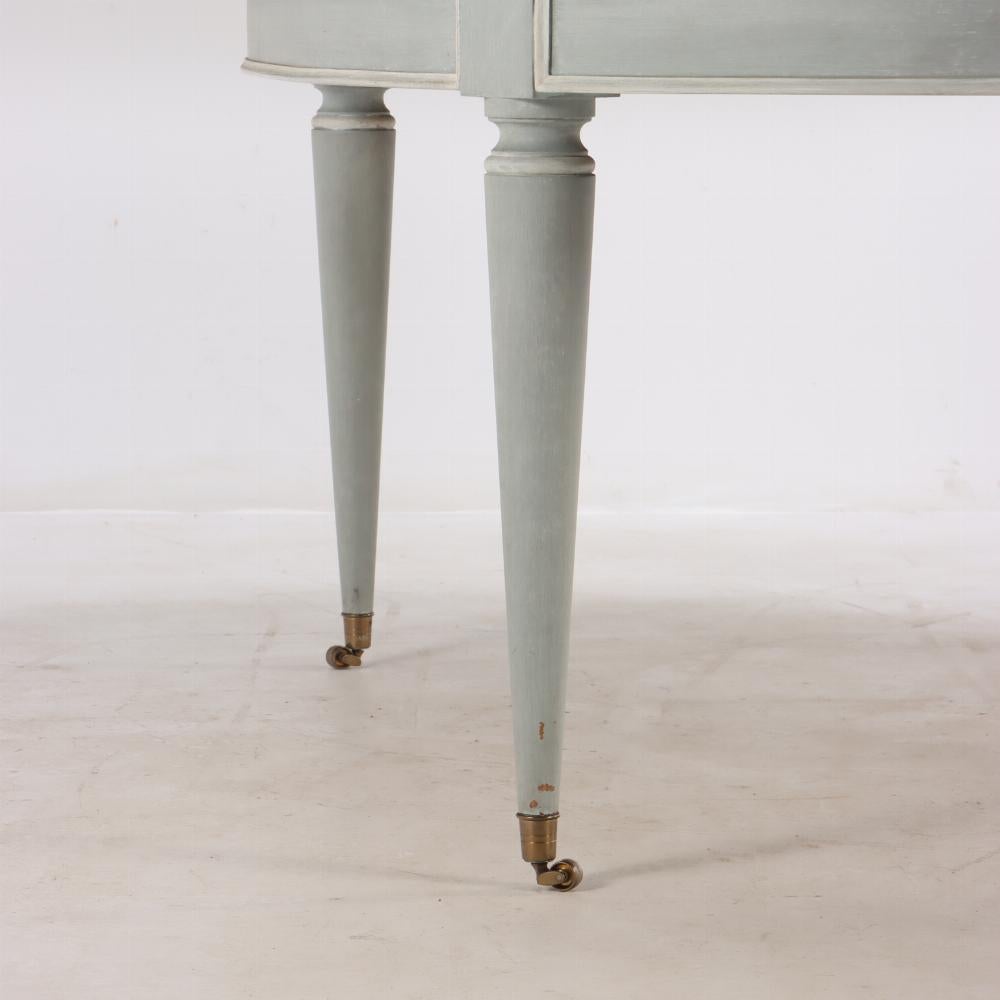 This oblong table with a dark top has white pinstriped details and round tapering legs. It was designed to open and extend for leaves the long way, but the additional leaves are not with the table any longer. A wonderful breakfast table with neutral