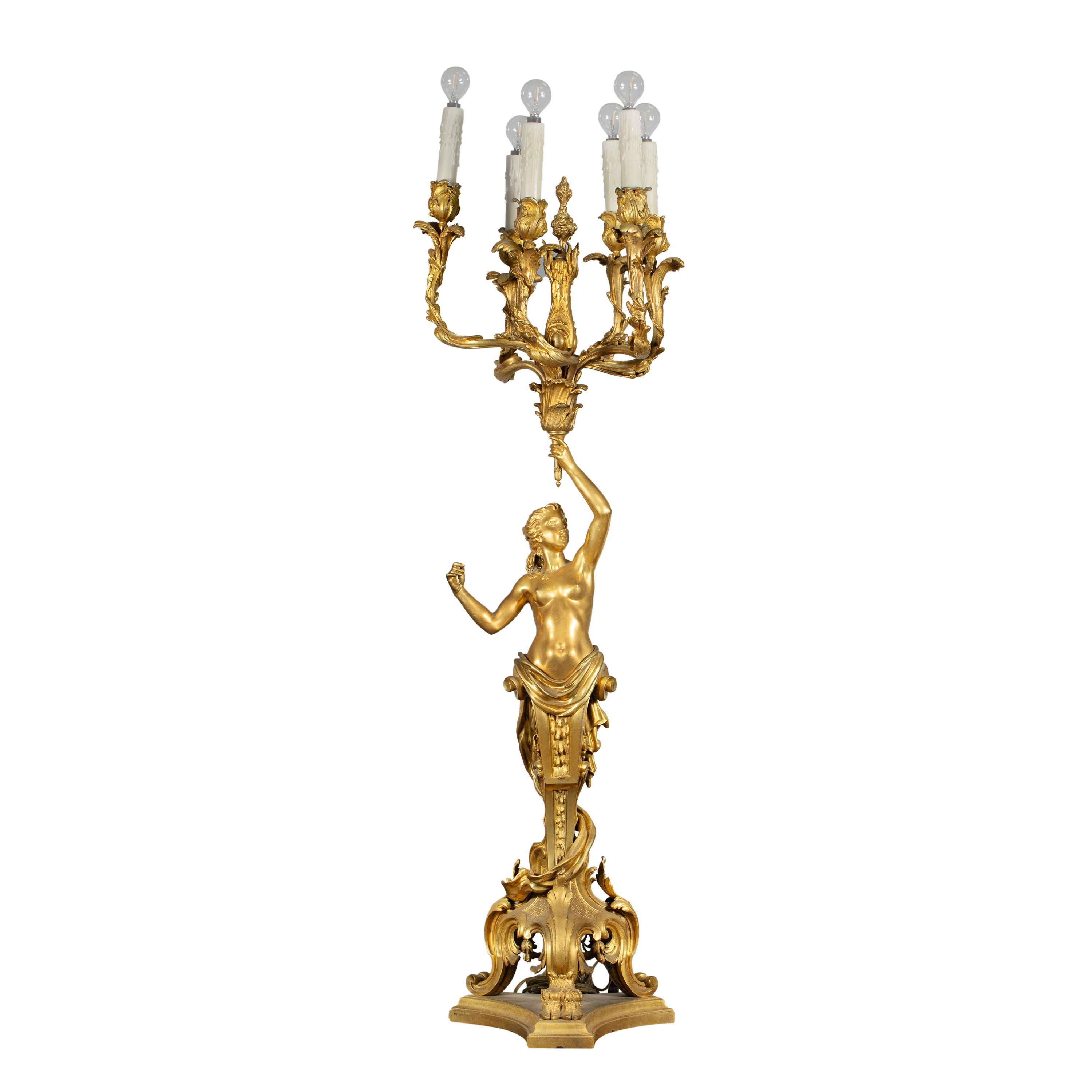 Une pièce grandiose en effet ! Ce grand candélabre à cinq branches en bronze doré, réalisé au XIXe siècle, s'inspire des modèles créés par Claude Michel Clodion. Connu pour son design et son art complexes, le candélabre présente des détails