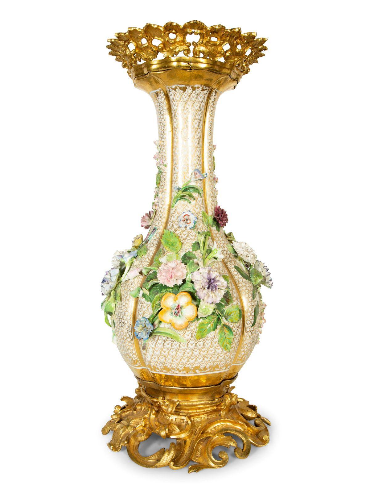 Vaso in porcellana francese di grande effetto, ornato da grappoli di fiori policromi applicati, con base e bordo in ormolu. XIX secolo
Misure: Altezza 26