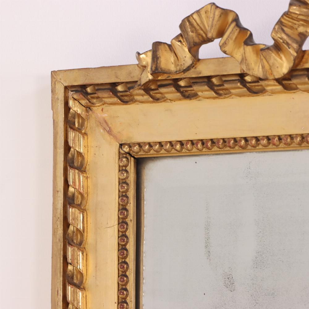 A large French giltwood mirror with ribbon crest, C. 1890. In Good Condition For Sale In Philadelphia, PA
