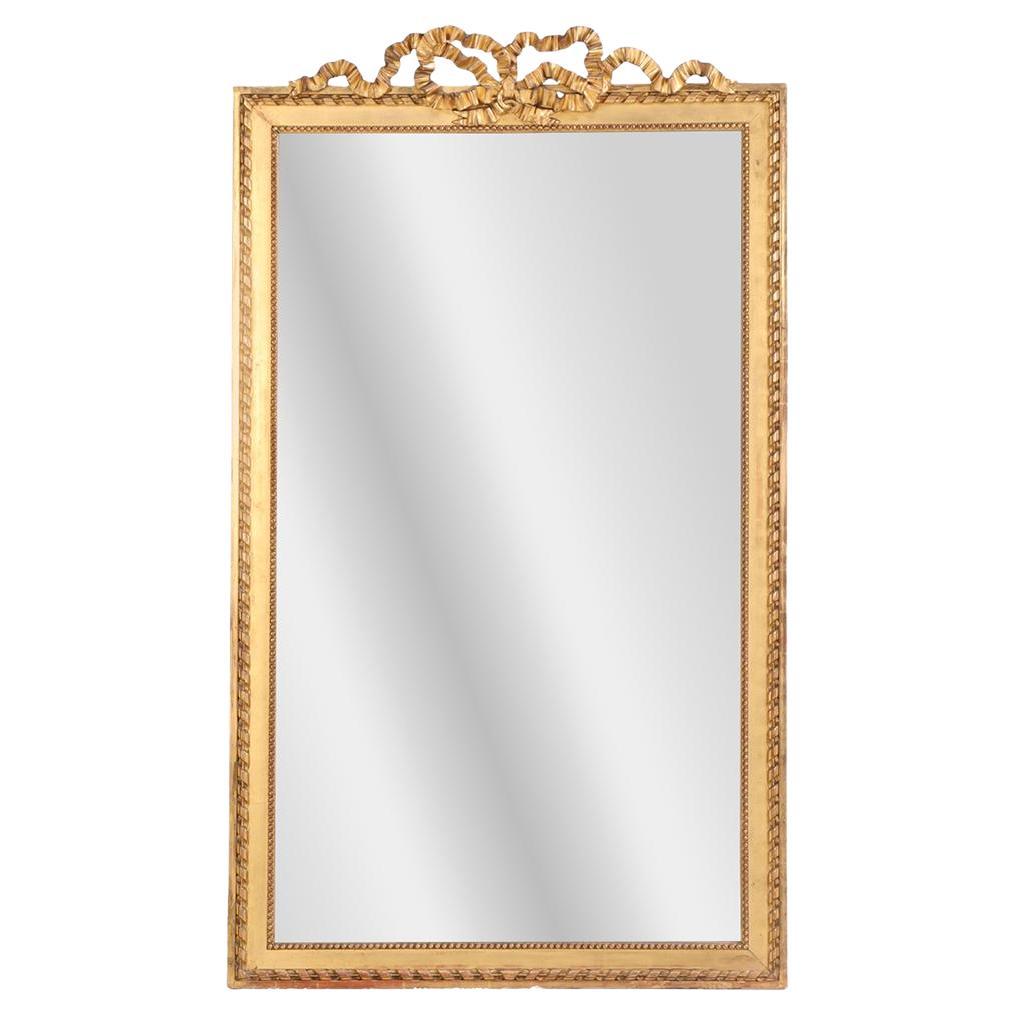 A large French giltwood mirror with ribbon crest, C. 1890. For Sale