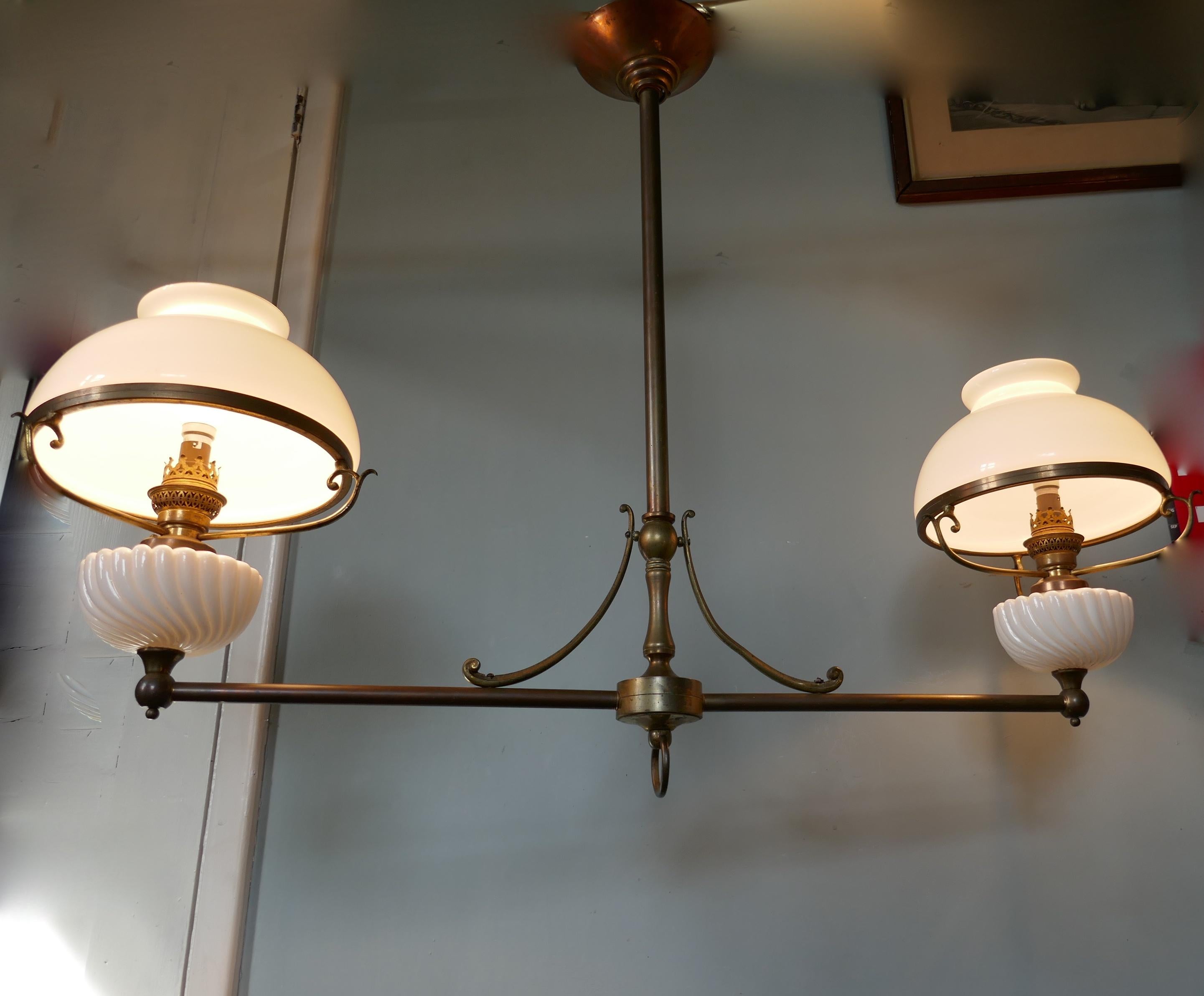 A large French hanging dining table double oil lamp. 

This is an elegant piece, formerly an oil lamp is converted for electricity, the style is similar to that used over a snooker table so lends itself very well to light a long dining table but