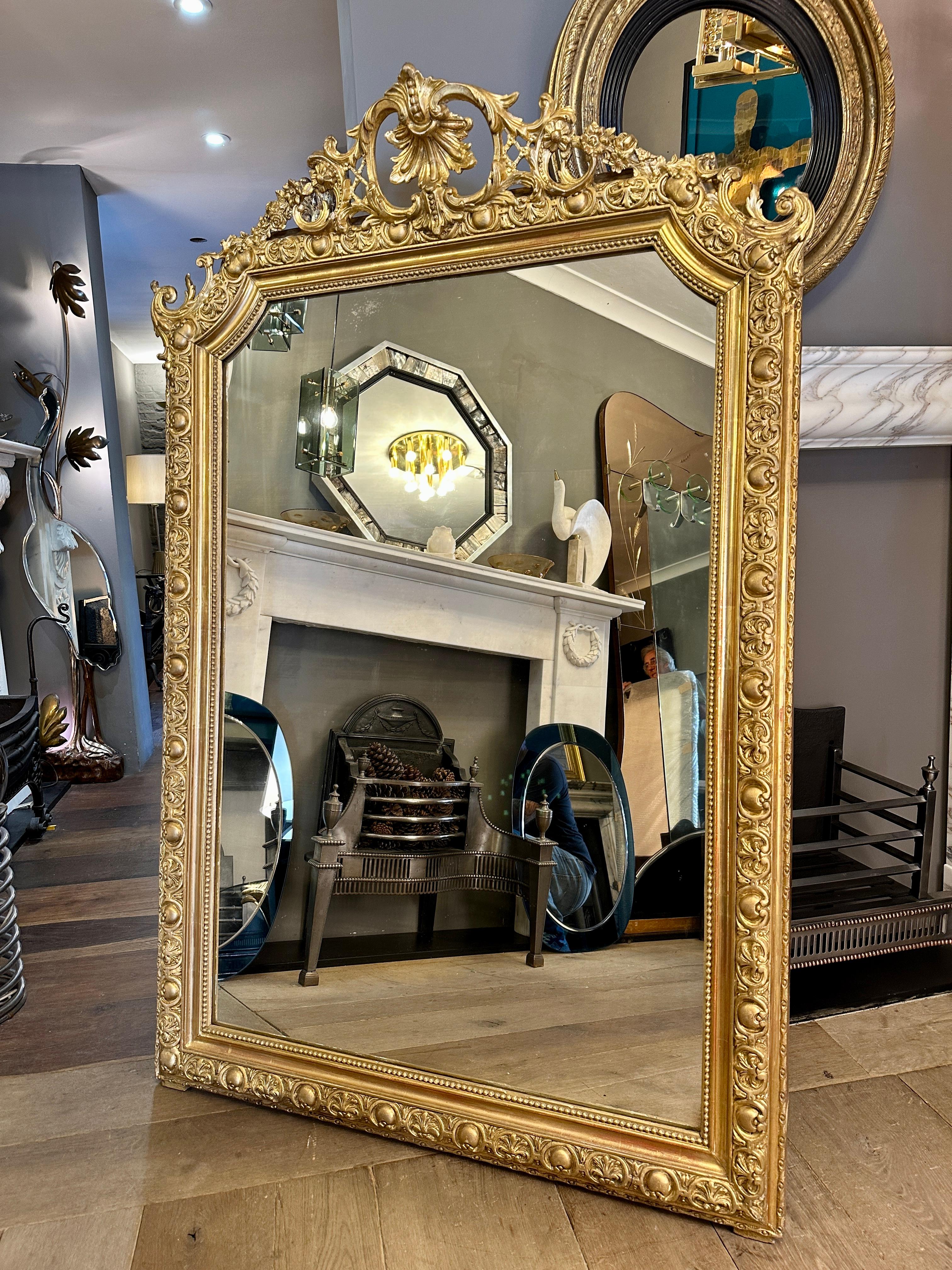 A large and ornate Napoleon III period gold gilt mirror, imported from Paris. Purchased from an apartment in the Avenue de Opera, with a Marie Antoinette countryside inspired design. Original plate and backboards. 