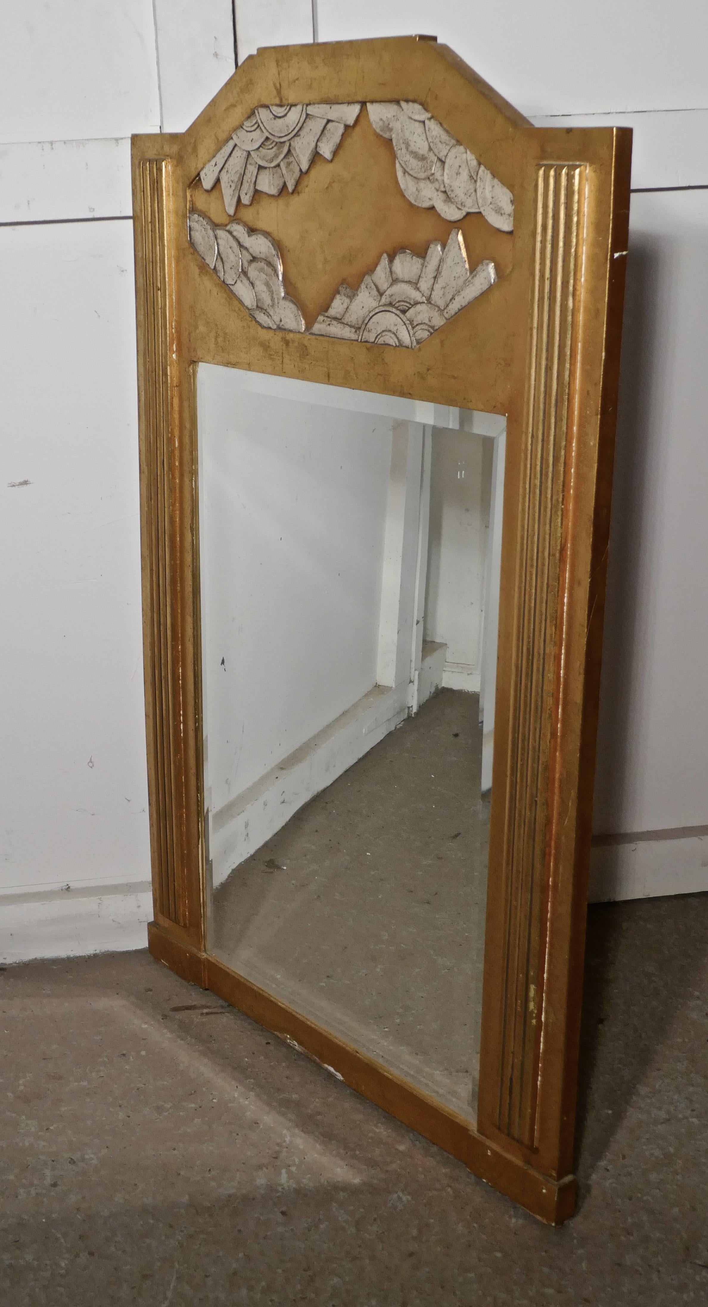 A large French Odeon style Art Deco gilt wall mirror.


This is a classic of its time, the mirror dates back to the early 1920s, it is made in wood with Gesso gold and silver finish
The wide frame has reeded decoration to the sides and a large