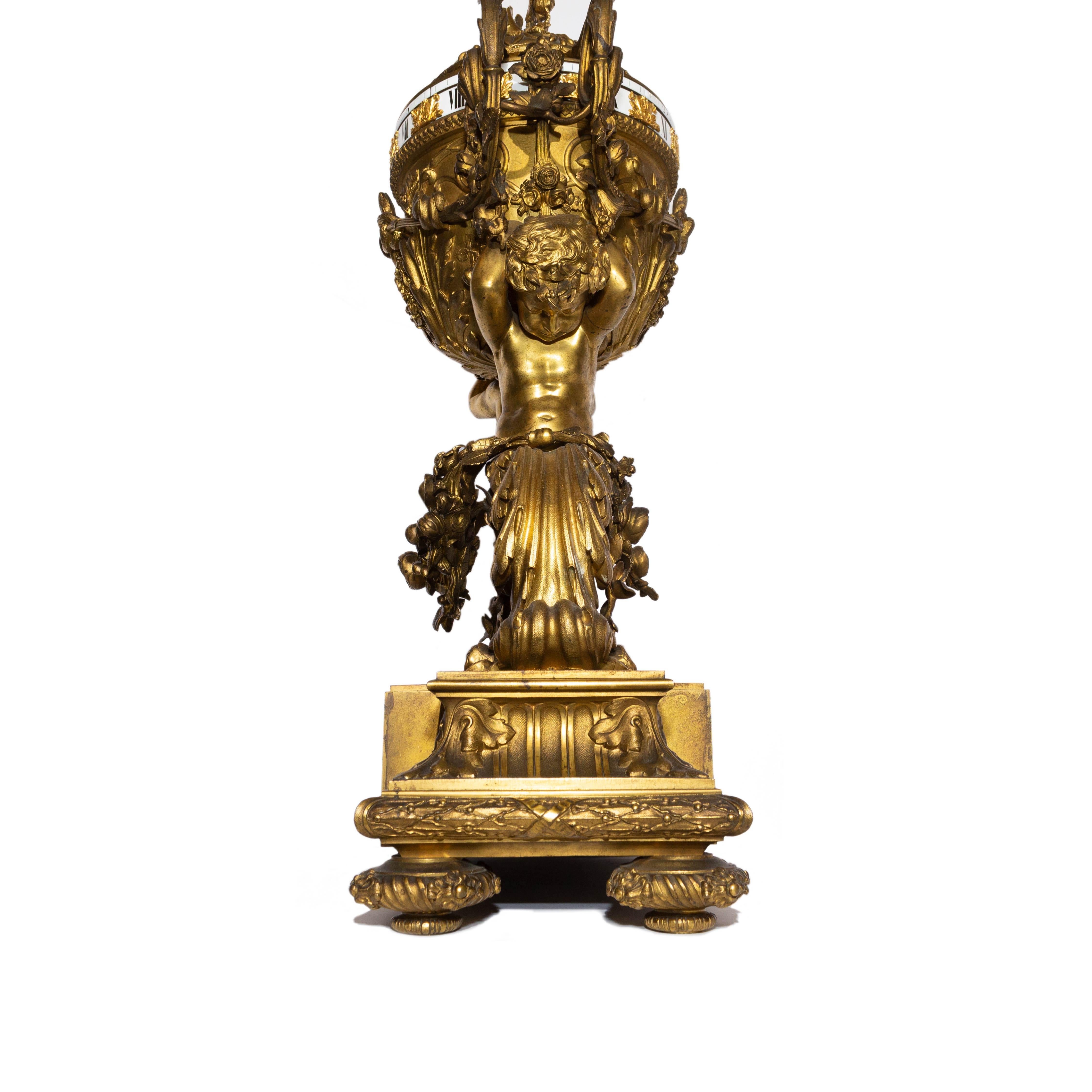 A Large Napoleon III ormolu Pendule À Cercles Tournants
Attributed to Deniere, after the model by Jean-François Forty, Paris, third quarter 19th century
Modeled as lidded vase, raised on the shoulders of two putto terms, on a shaped rectangular